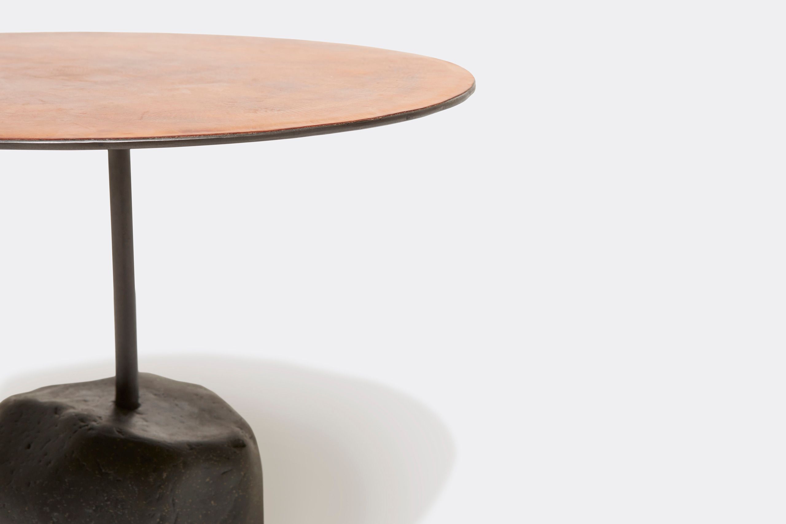 a round table with a brown leather top and a metal steel frame and stone base shown on a white background .