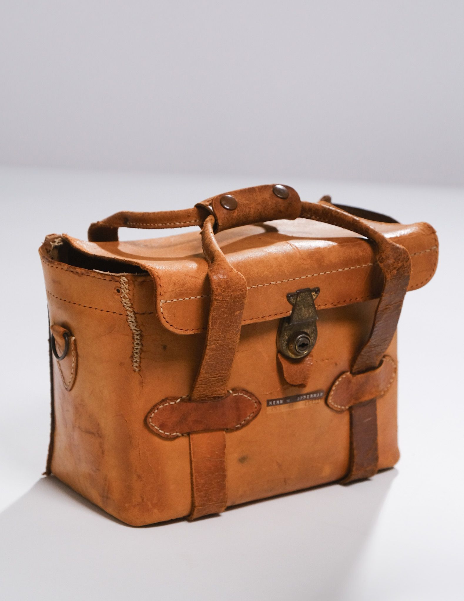 a brown leather camera case with a lock on it