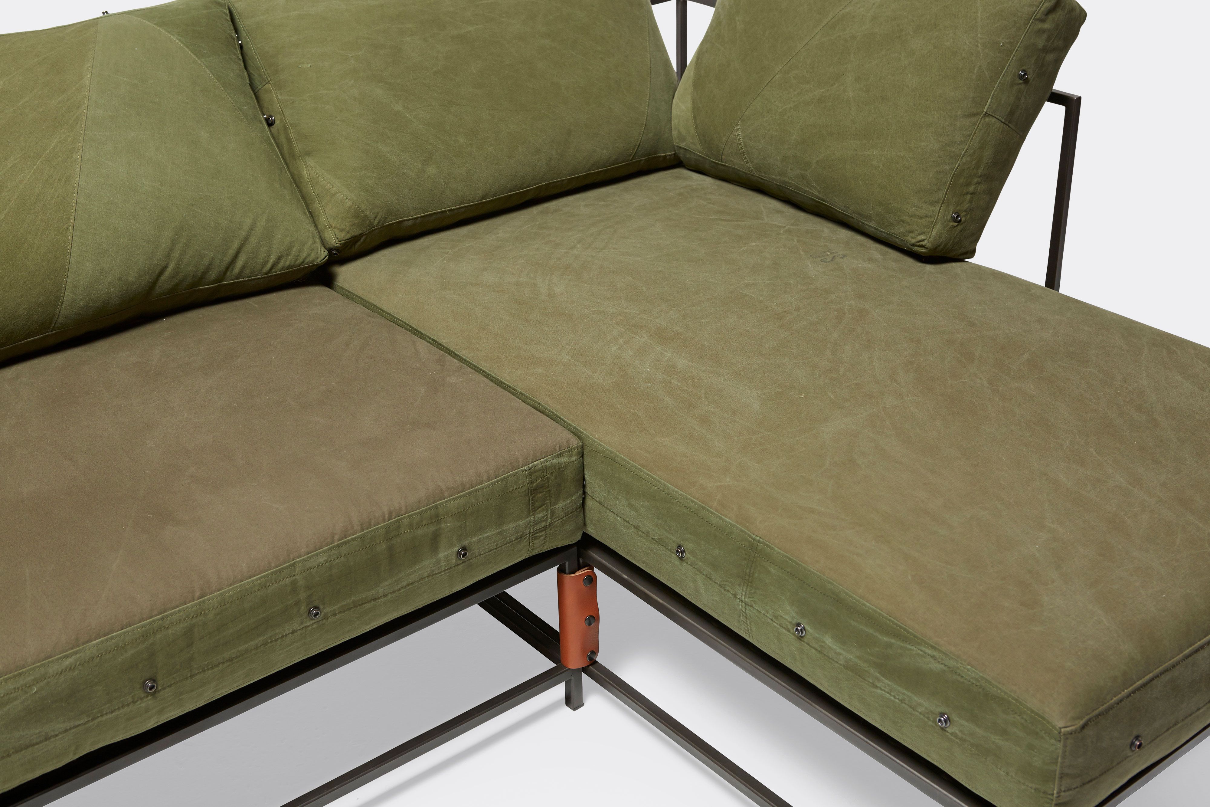 overhead detail side of sectional with green canvas upholstery on black metal frame