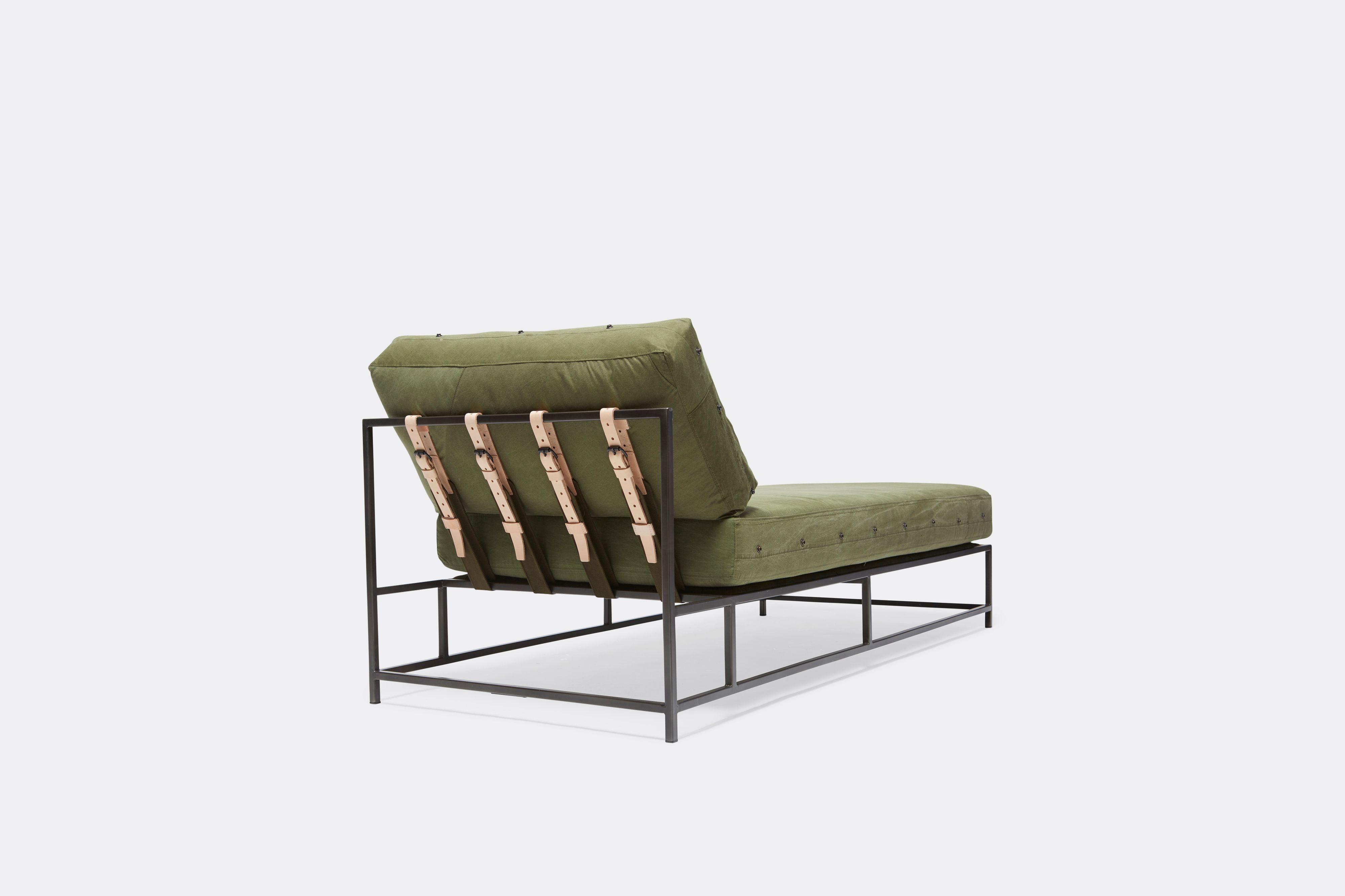 side view of military canvas chaise lounge with blackened steel frame and leather belts