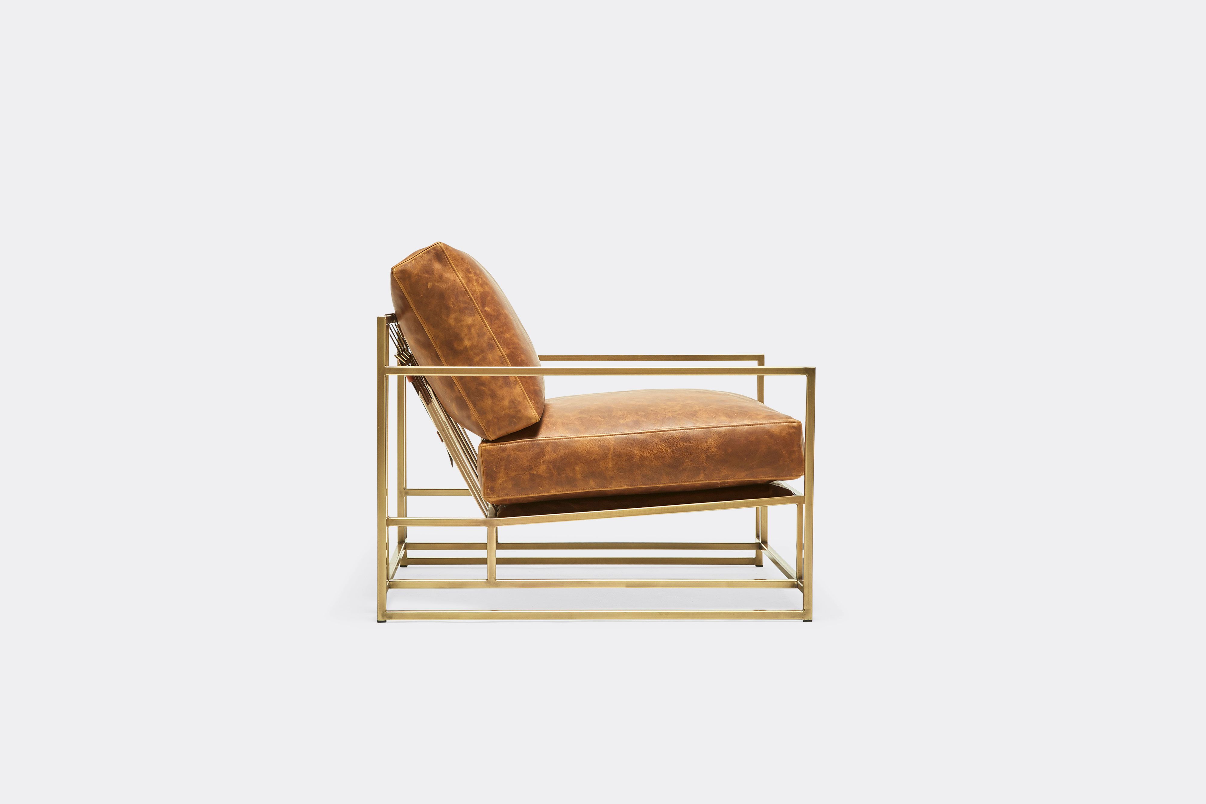 side of armchair with brown leather upholstery on antique brass metal frame