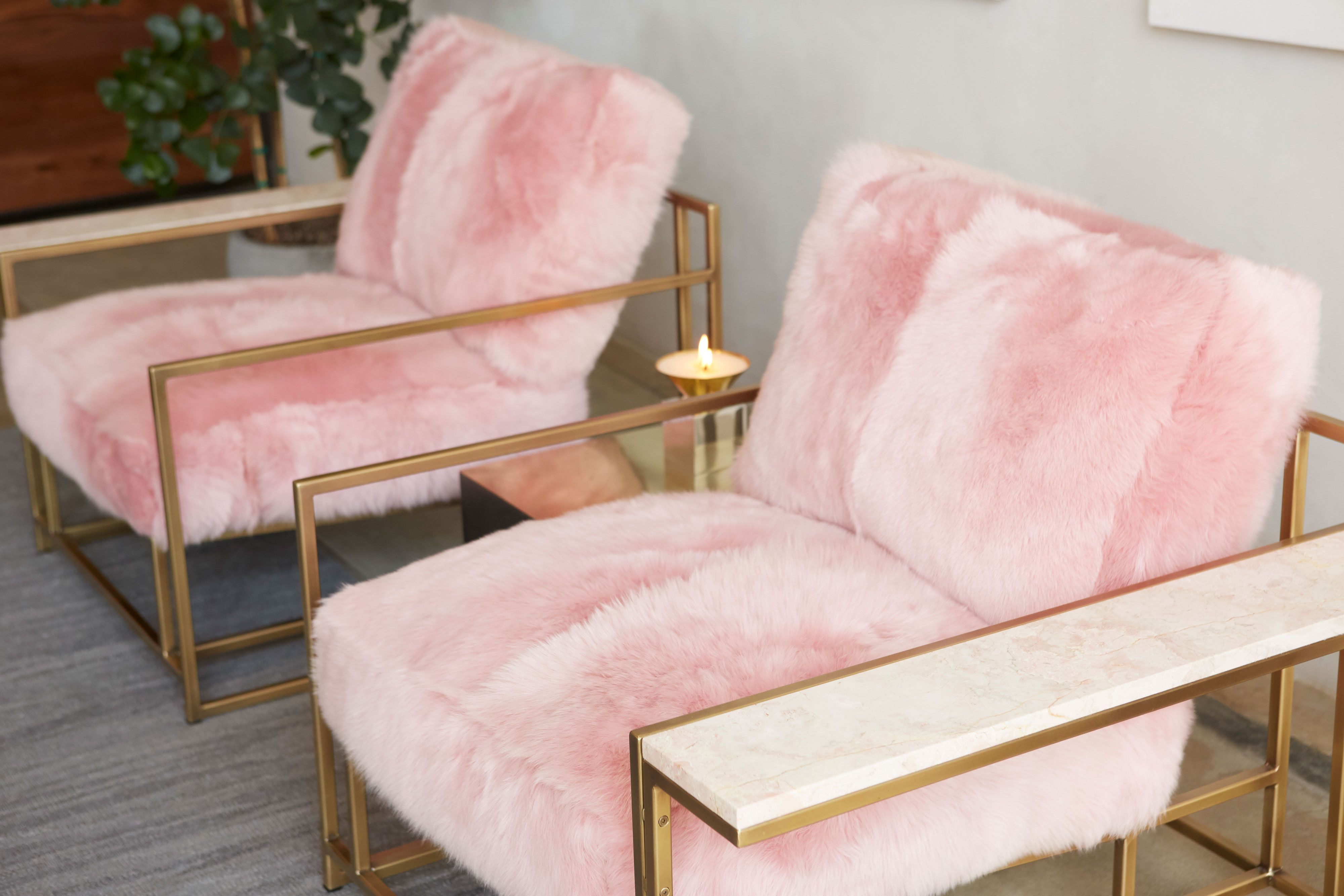 two armchairs with pink shearing upholstery on antique brass metal frame