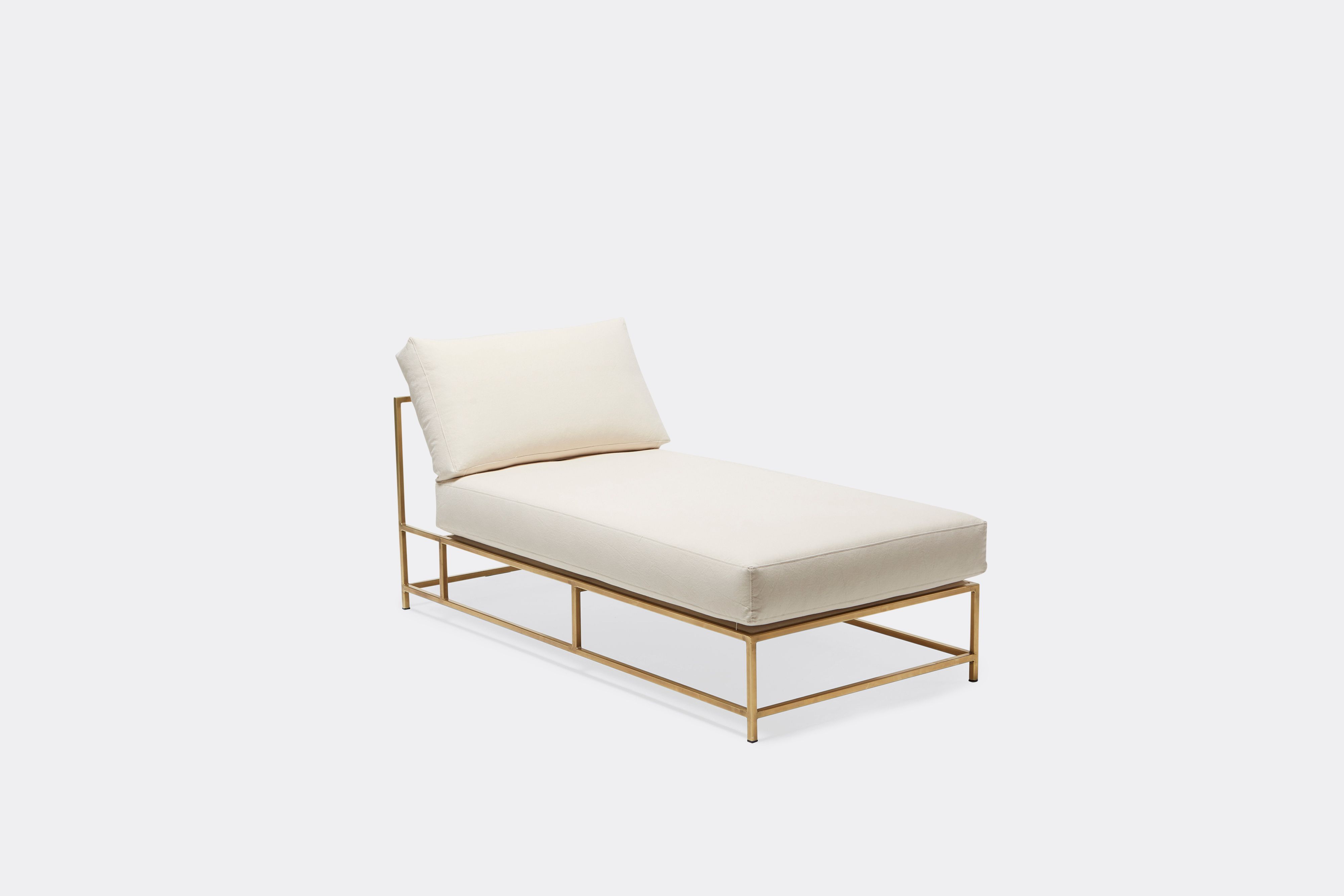 Overhead view of lounge chaise with natural canvas upholstery and brown leather belt on tarnished brass metal frame