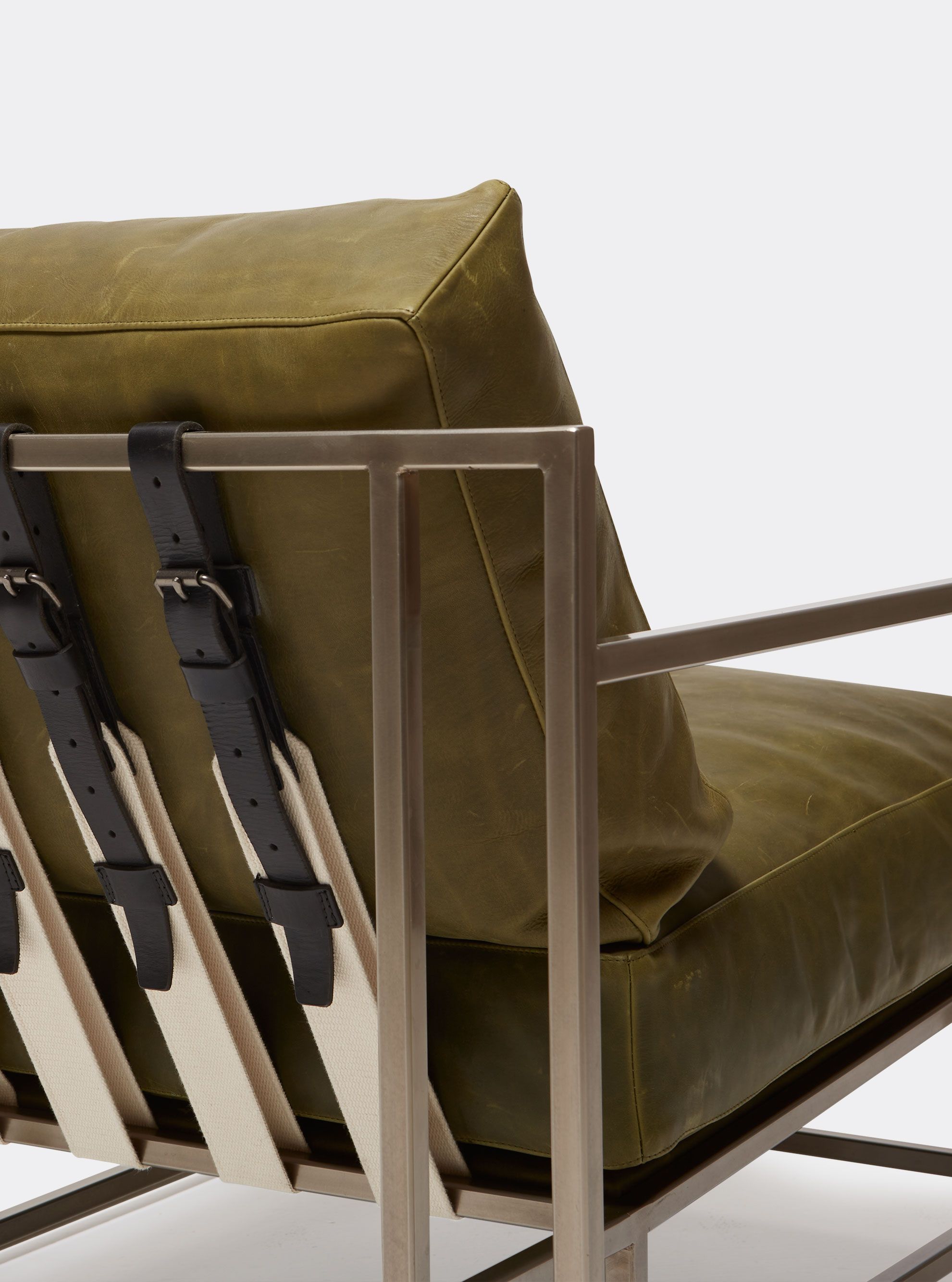a green leather upholstered armchair with a steel frame and leather and webbing supporting belts shown on a white background