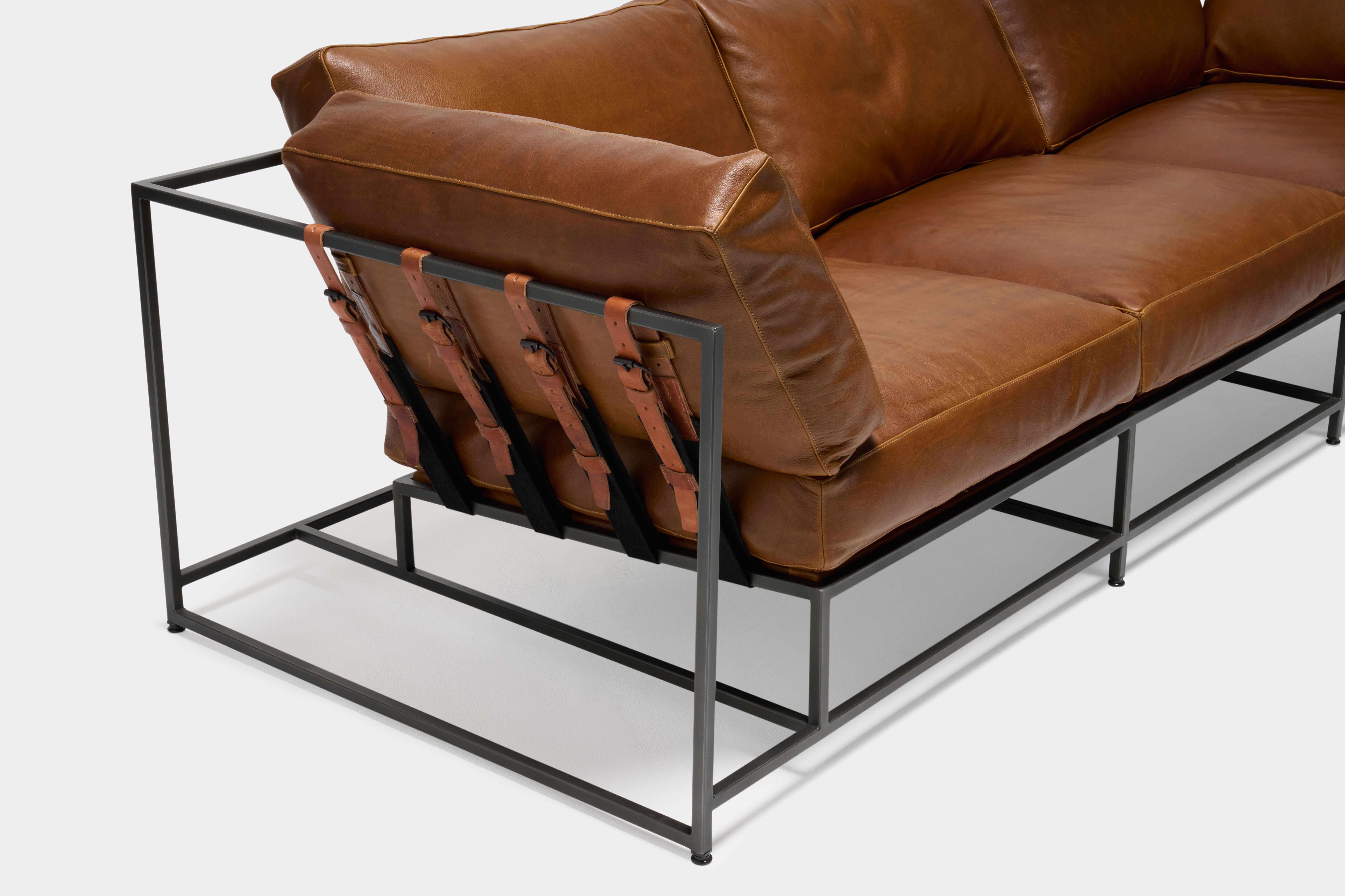 overhead of Sofa with brown leather upholstery and brown leather belts on black metal frame