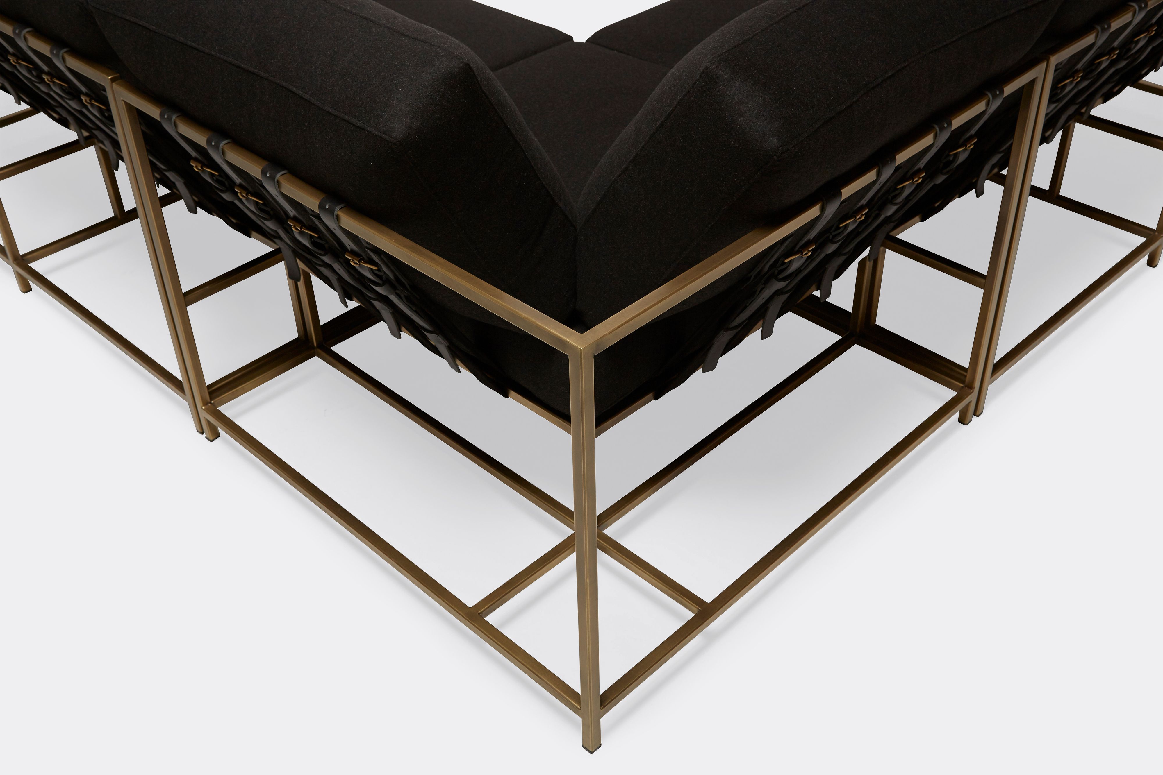 detail of sectional with black wool upholstery on antique brass metal frame