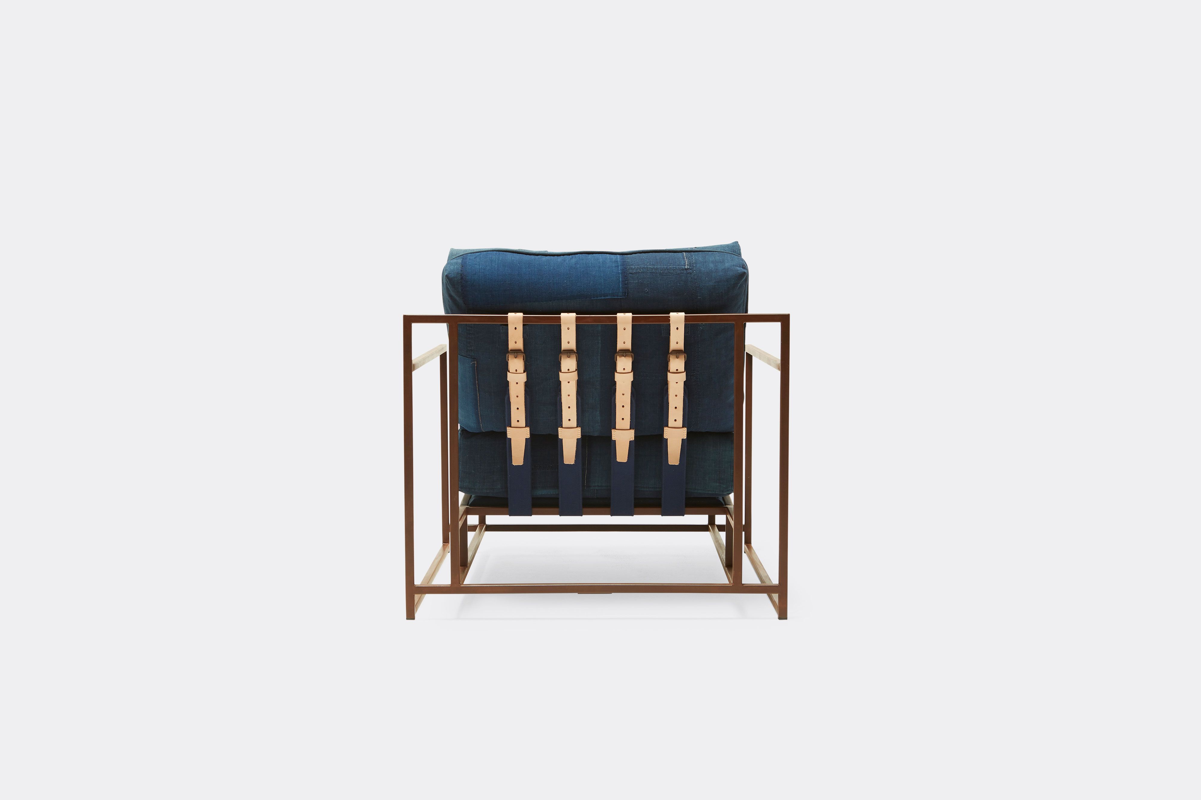 back of armchair with vintage boro upholstery and tan leather belts on marbled rust metal frame