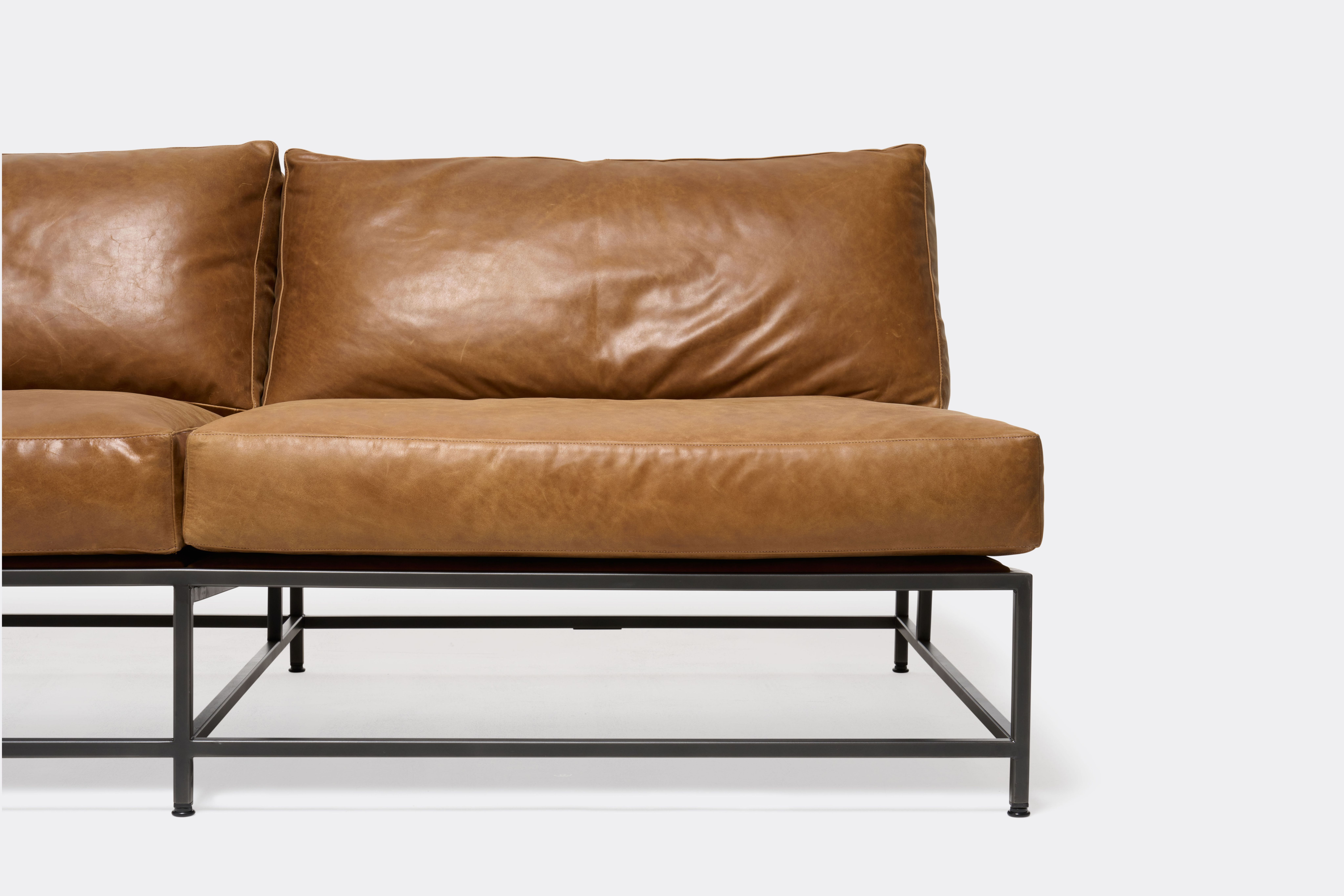 detail front of loveseat with brown leather upholstery on black metal frame