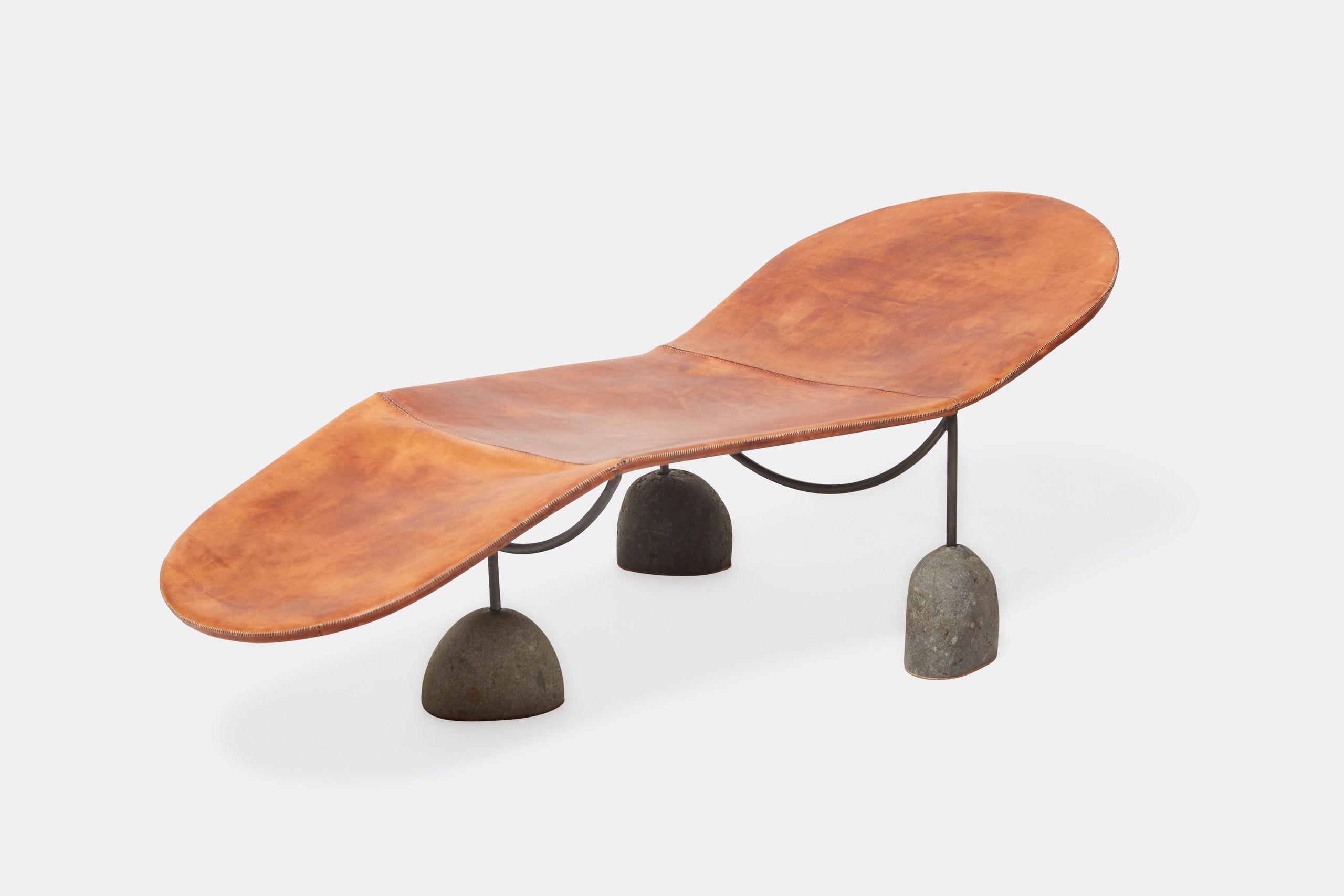 a brown leather chaise lounge with a steel frame and stone base shown on a white background .