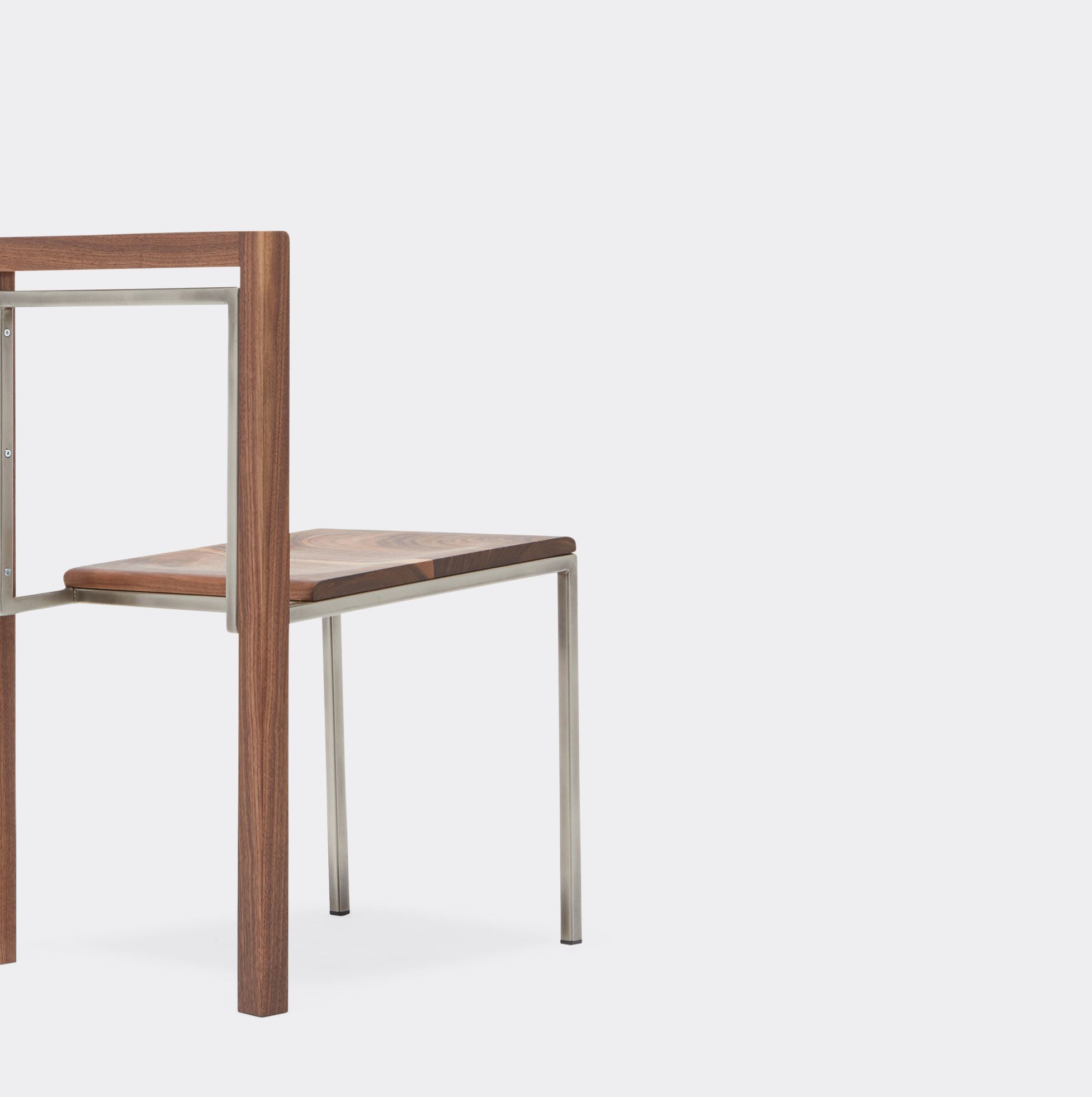 a wood dining chair with a nickel finished metal frame shown on a white background .