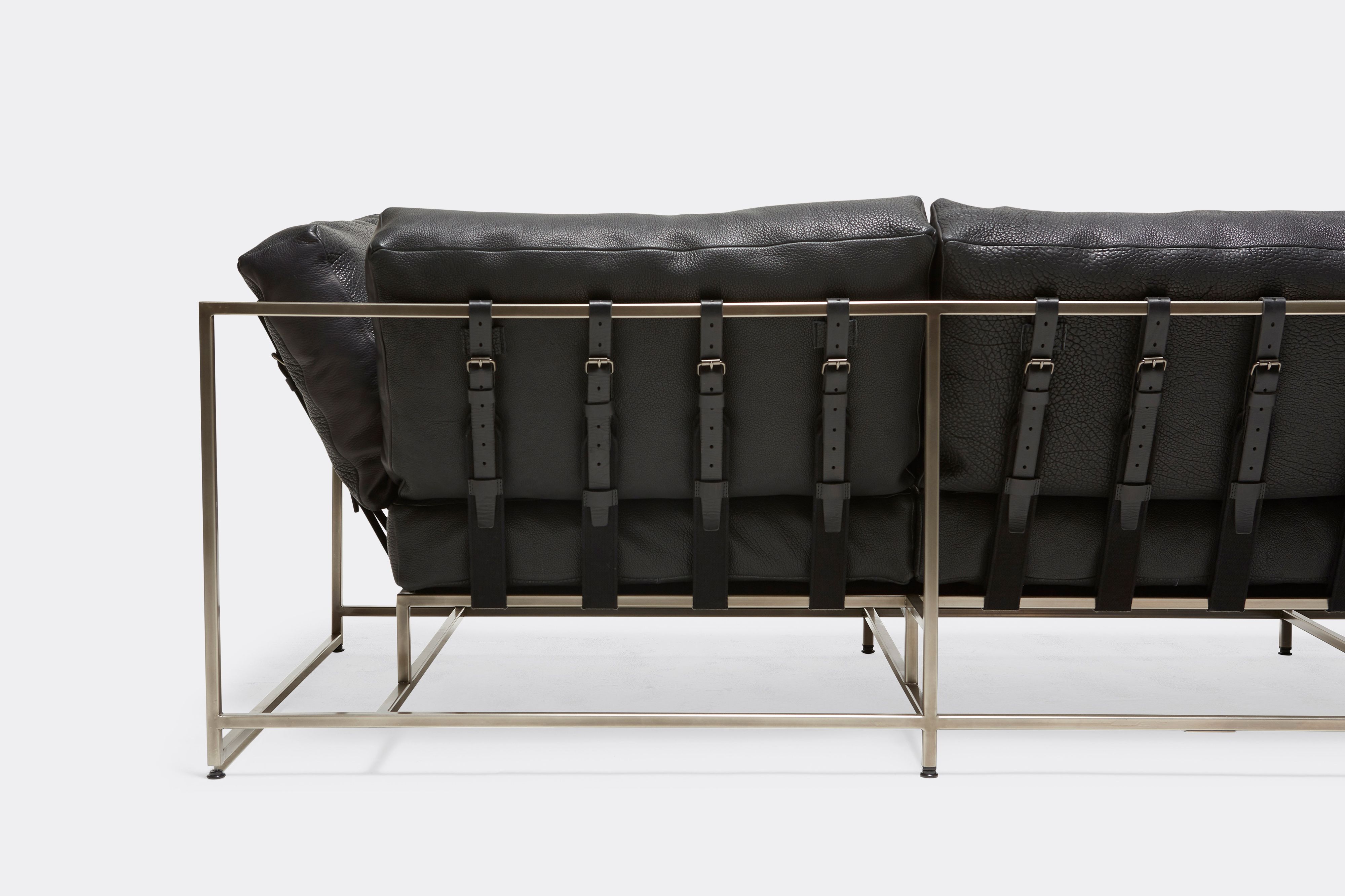 Back detail of Sofa with black leather upholstery and black leather belts on antique nickel metal frame