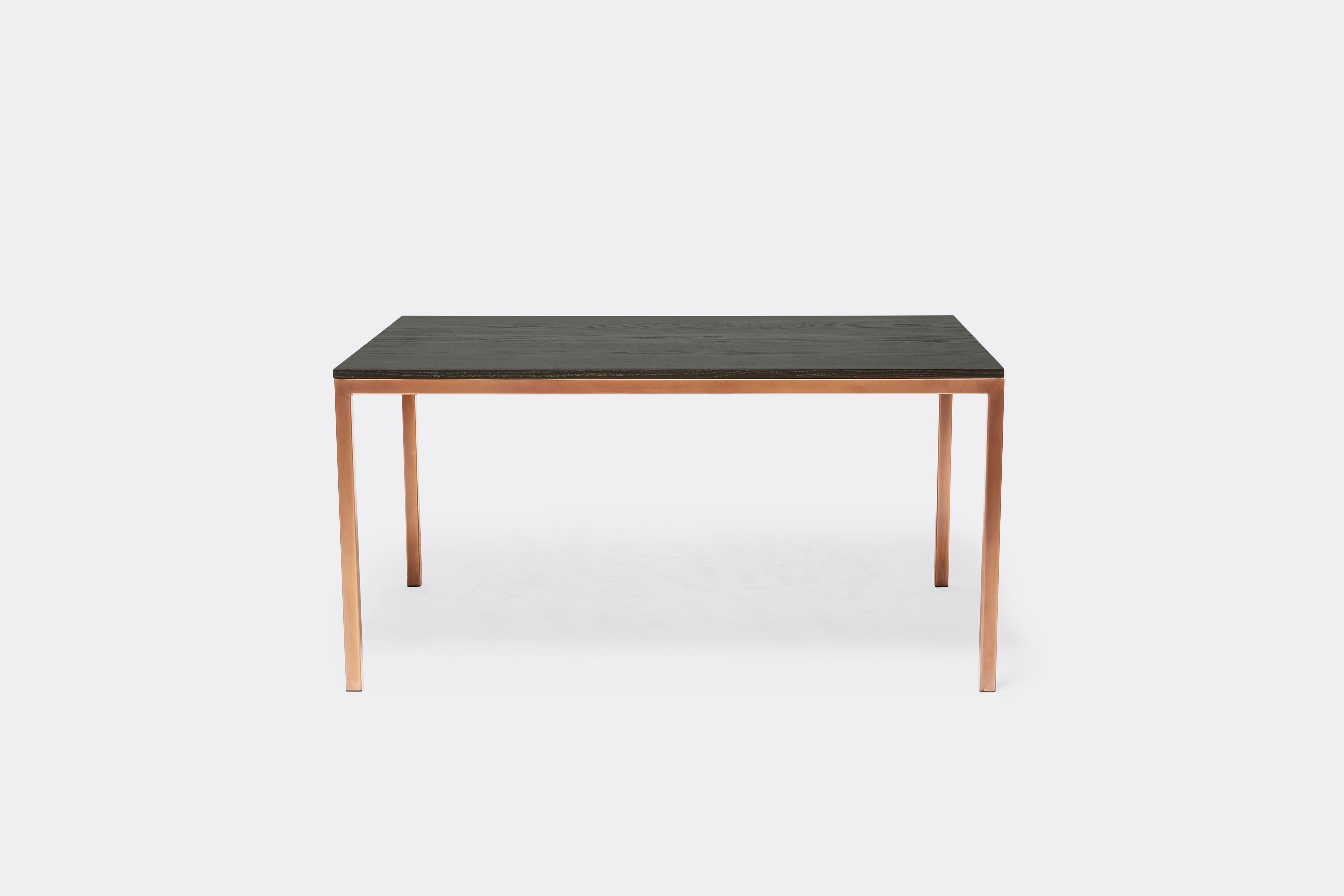Sideview of dining table with ebonized oak wood top and antique copper metal legs