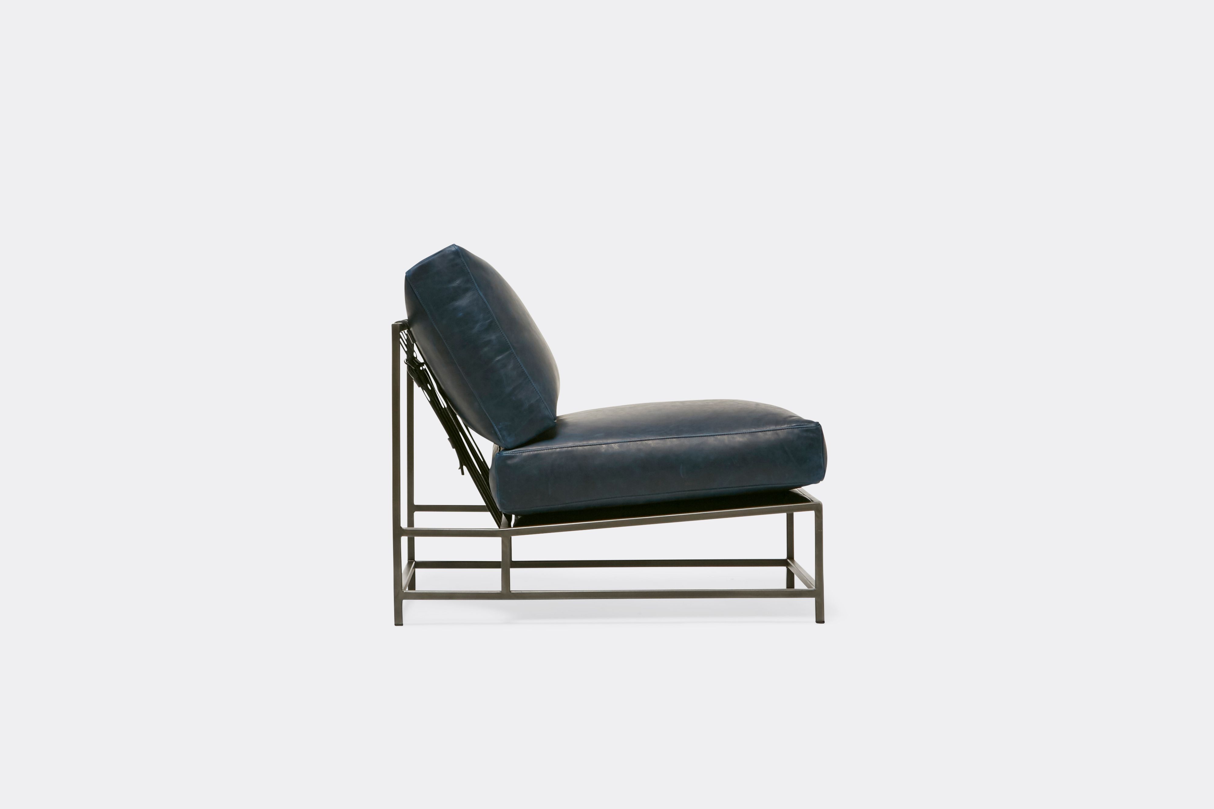 side of lounge chair  with blue leather upholstery on antique nickel metal frame