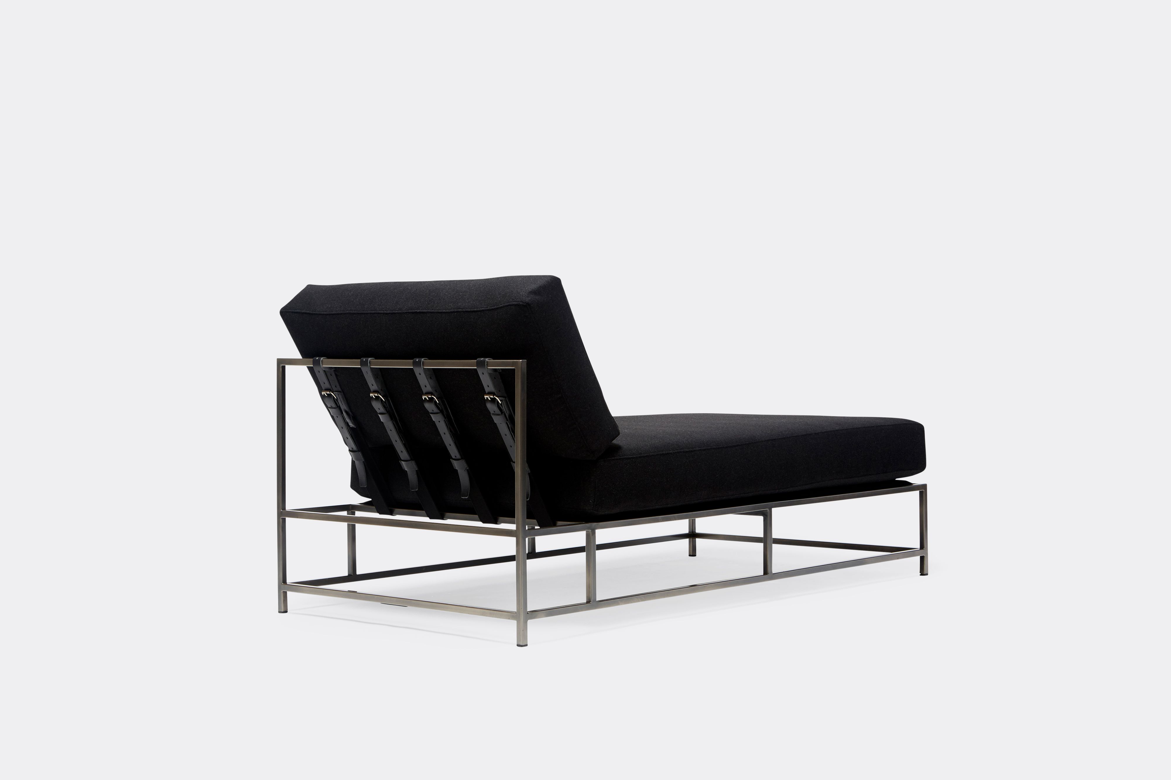 back of chaise lounge with black wool upholstery and black leather belts on antique nickel metal frame