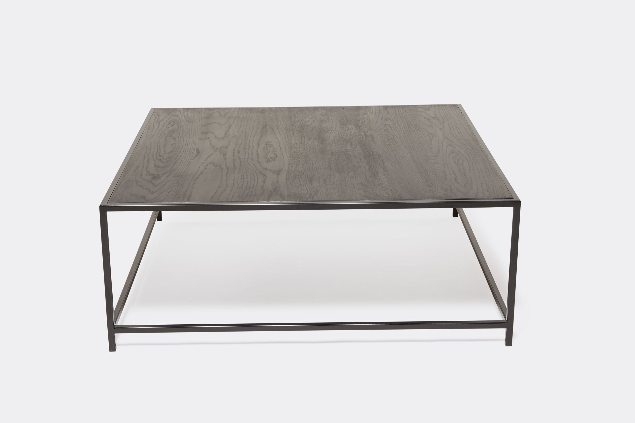 a black wood topped coffee table with a metal frame on a white background .