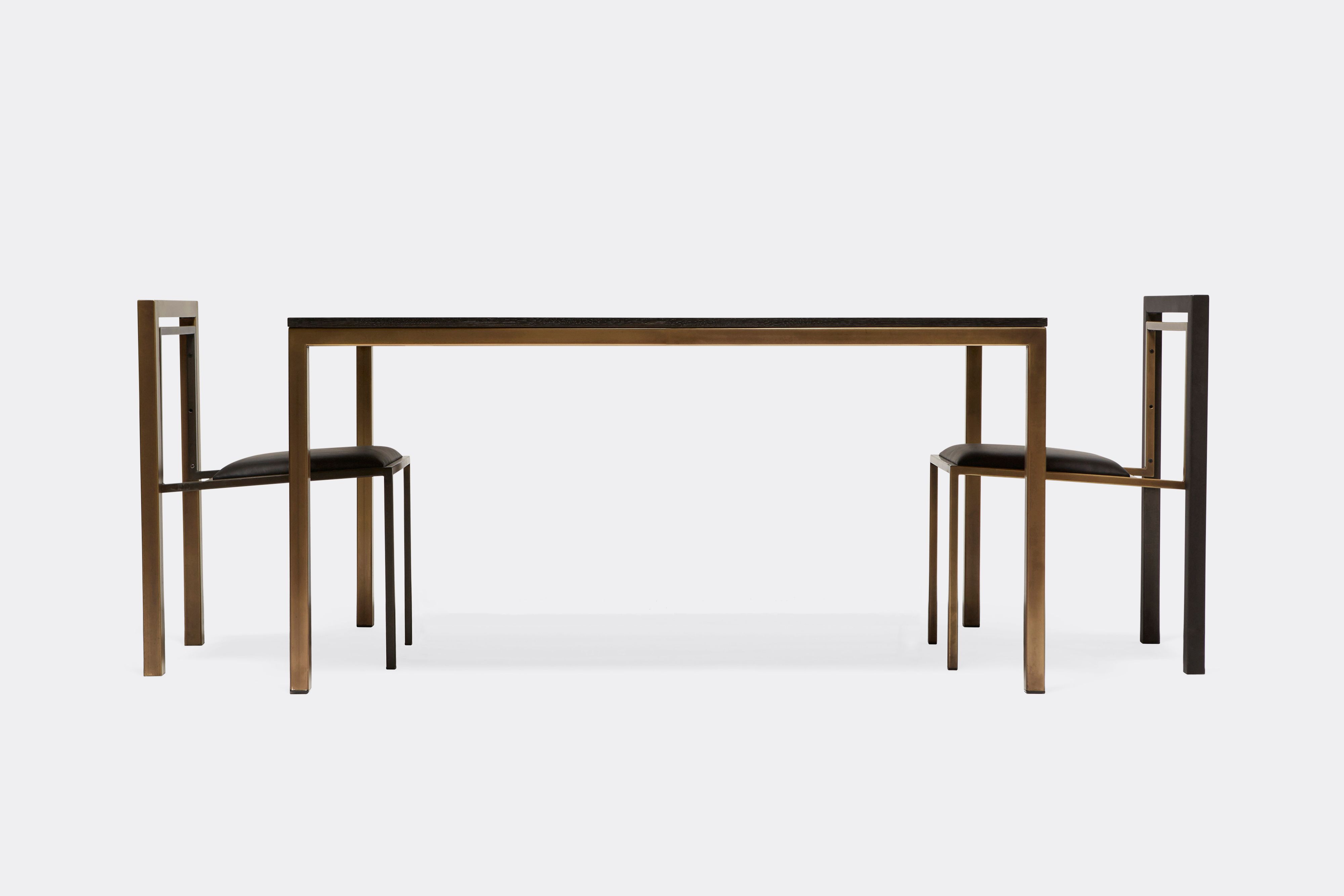 Sideview of dining table and chairs. Table ebonized oak wood top and antique brass metal legs
