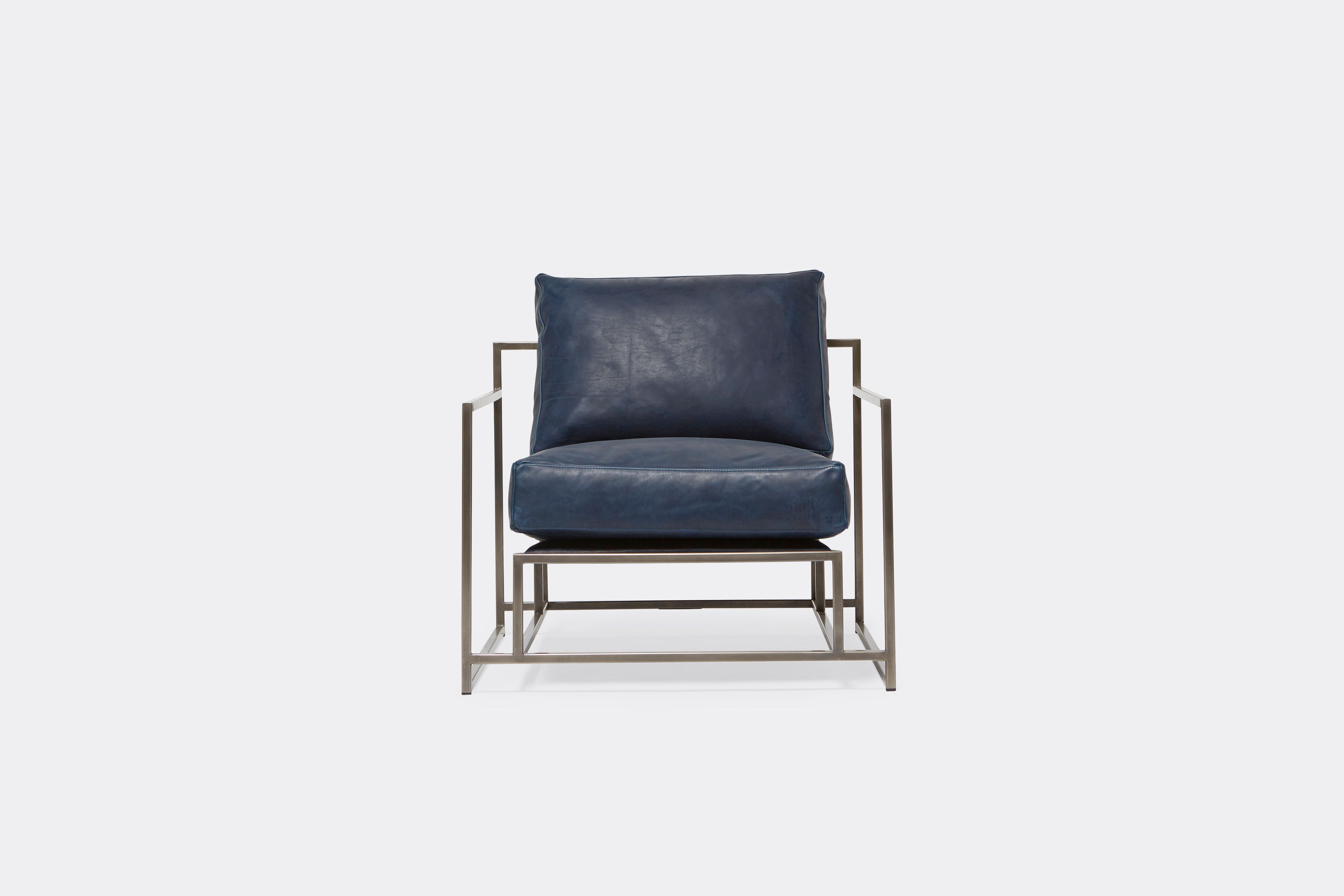 front of armchair with blue leather upholstery on antique nickel metal frame