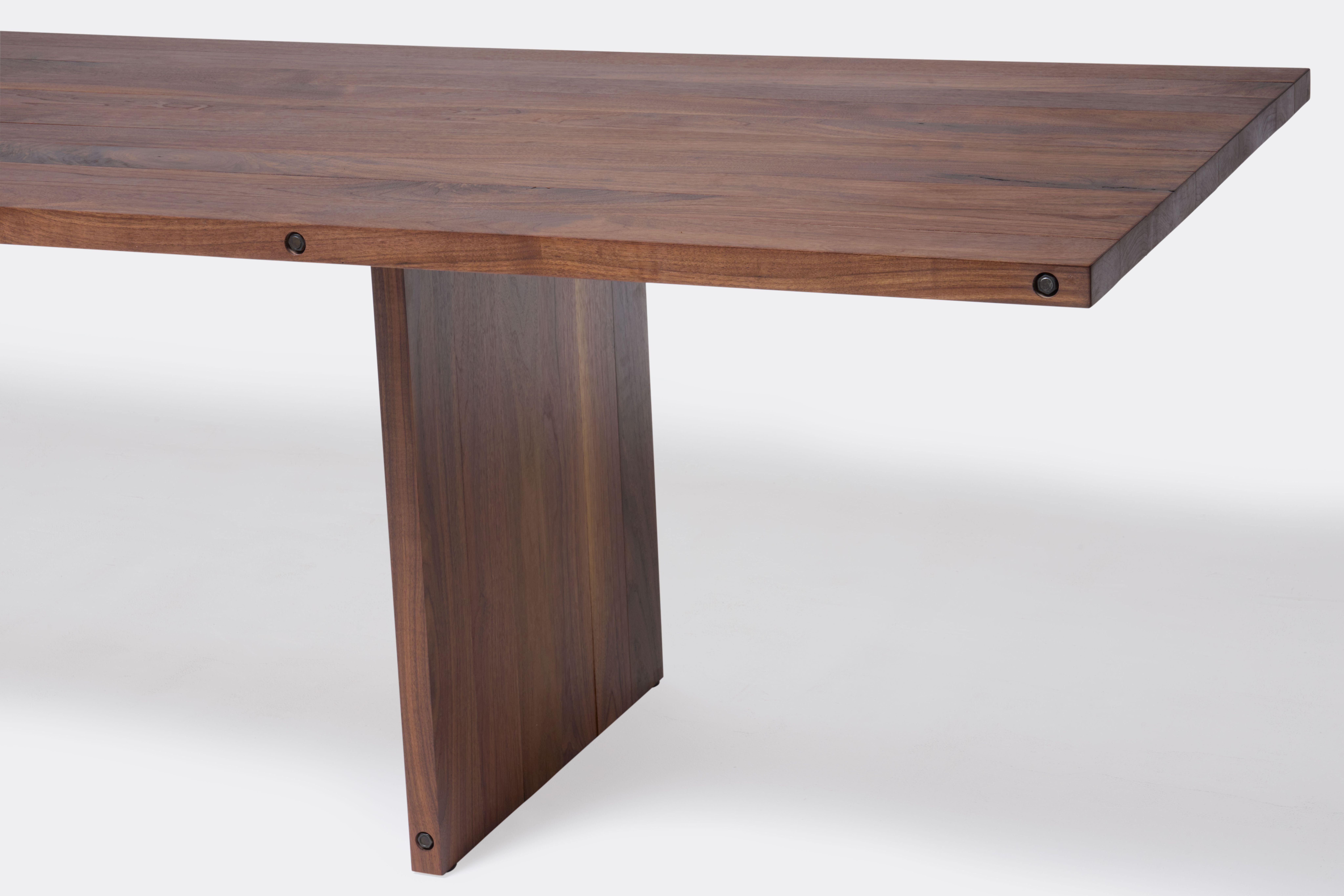 a long walnut wooden table on a white background .