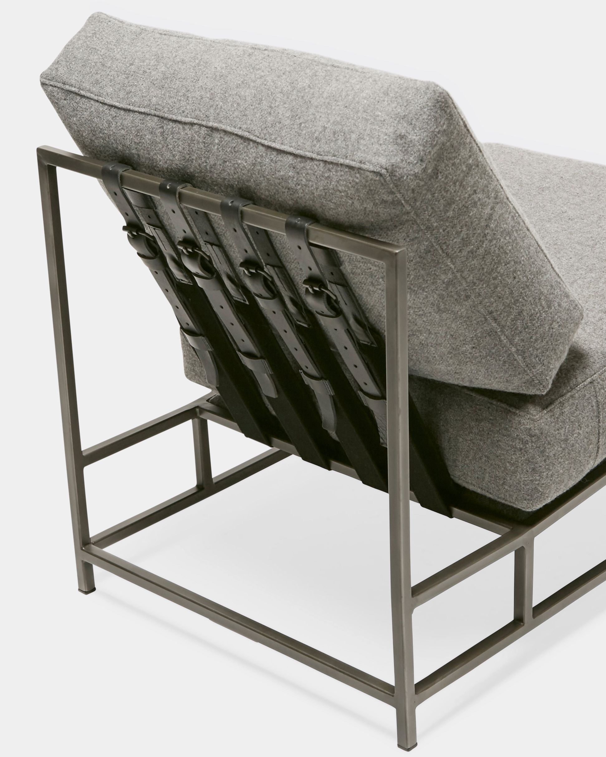 a grey wool chair with a metal frame and black supporting belts on a white background .