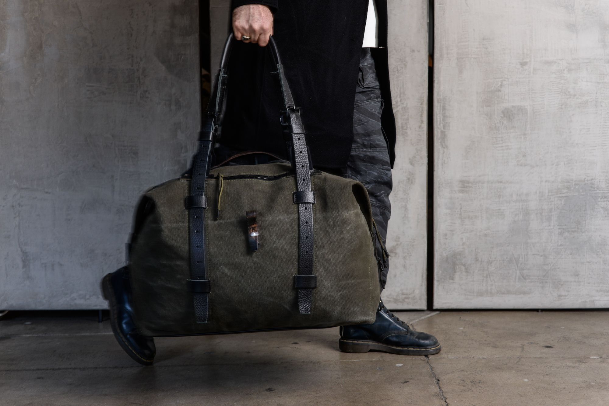 a man is holding a large green duffel bag .