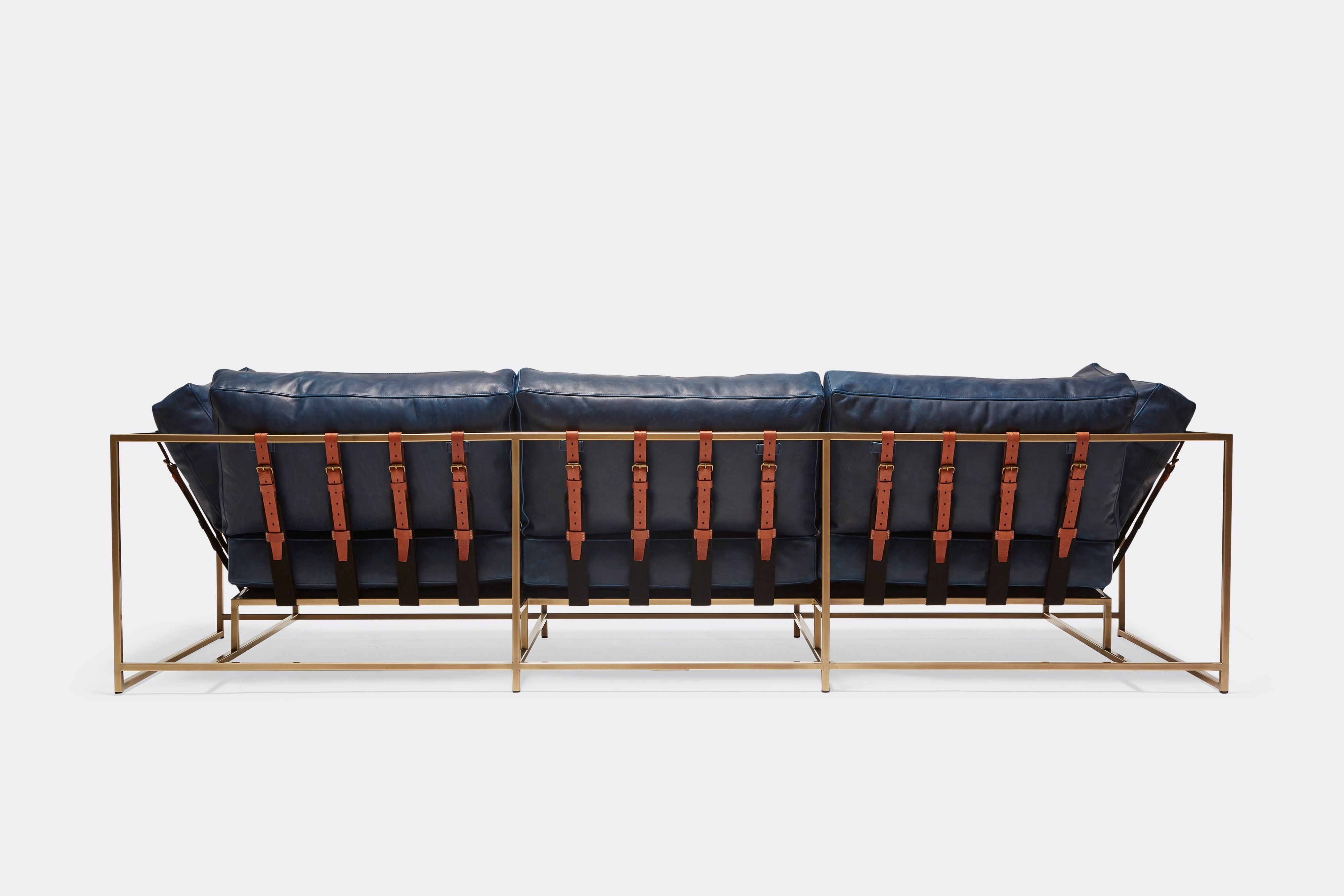 back of Sofa with Navy leather upholstery and brown leather belts on antique brass metal frame