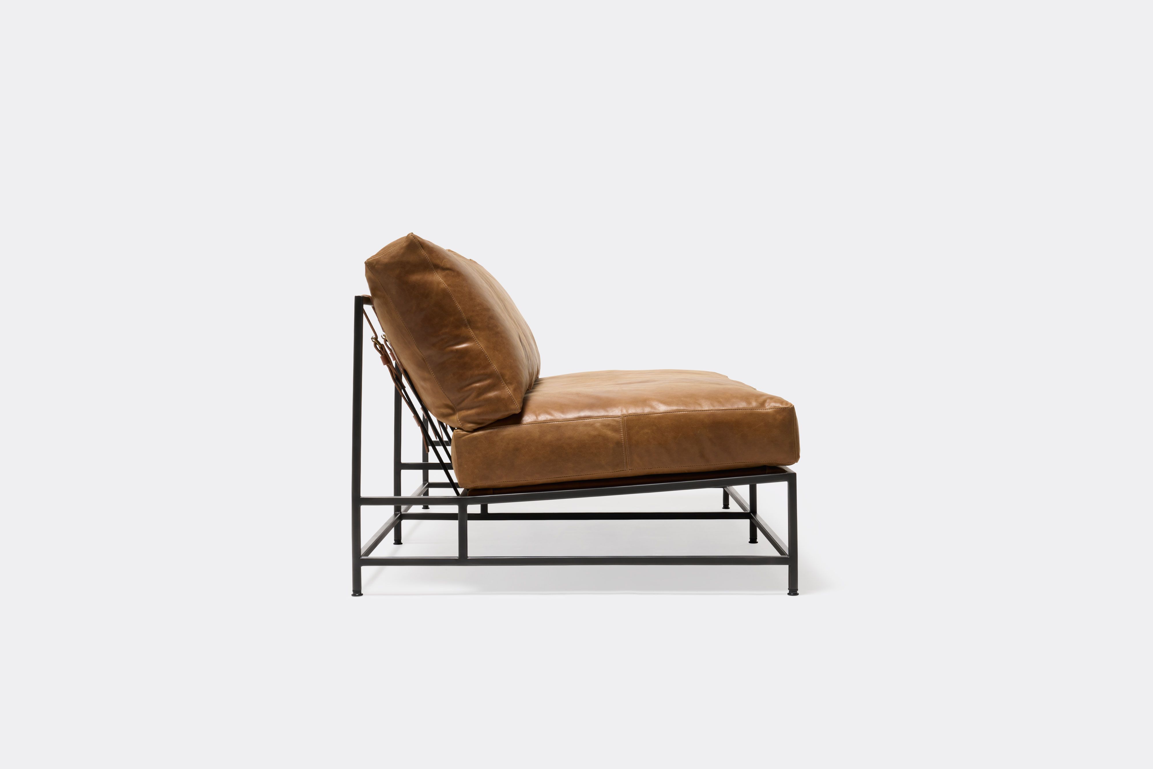 side of loveseat with brown leather upholstery on black metal frame