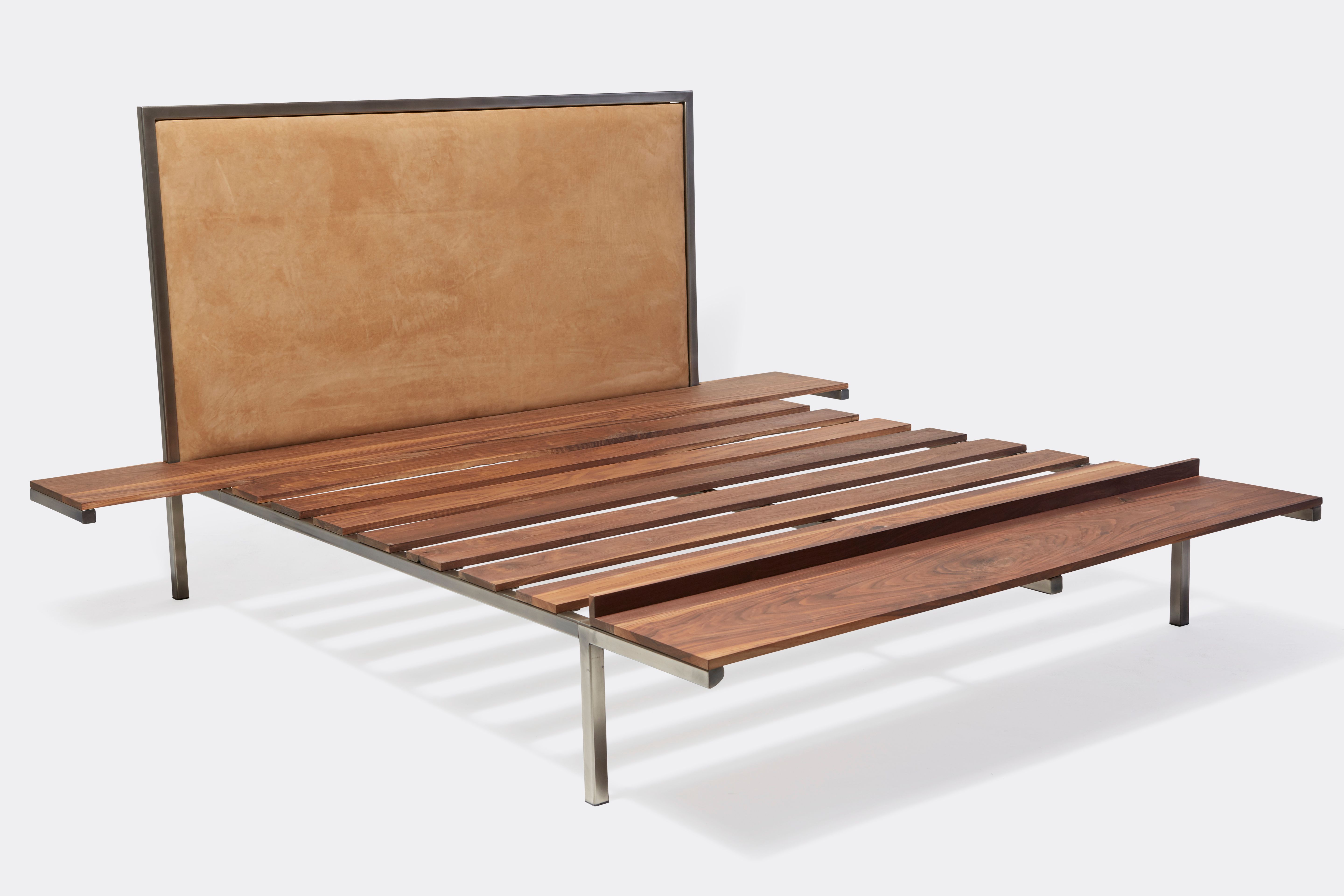 a steel and walnut wood bed with a brown leather headboard on a white background