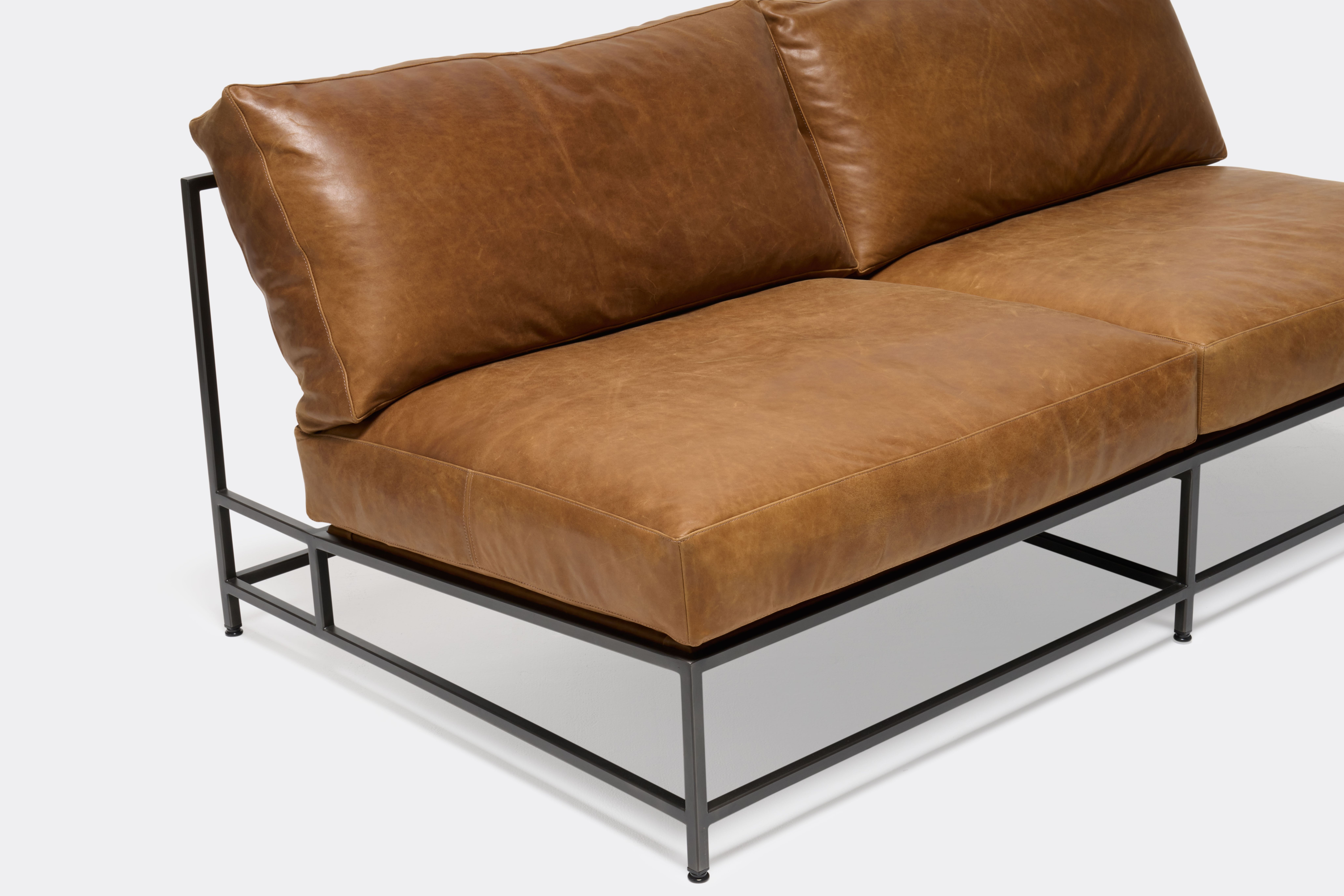 overhead of loveseat with brown leather upholstery on black metal frame