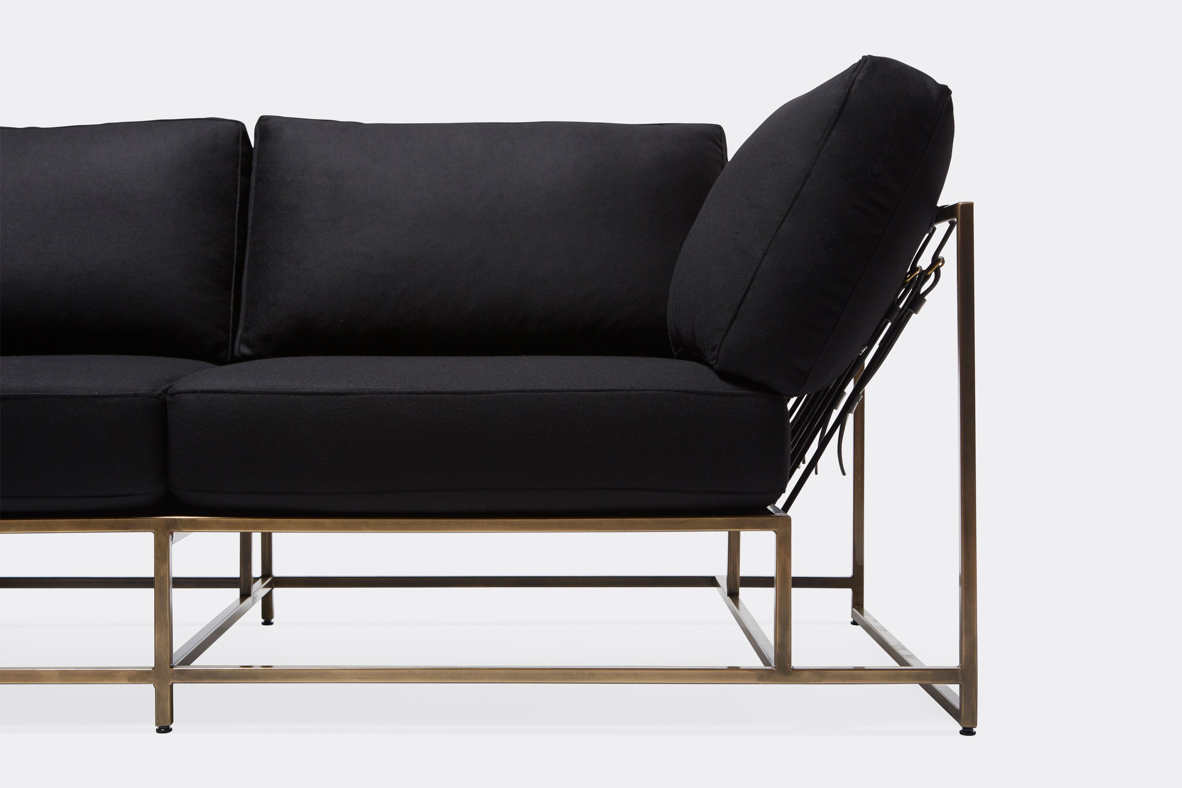 front detail of sectional with black wool upholstery on antique brass metal frame