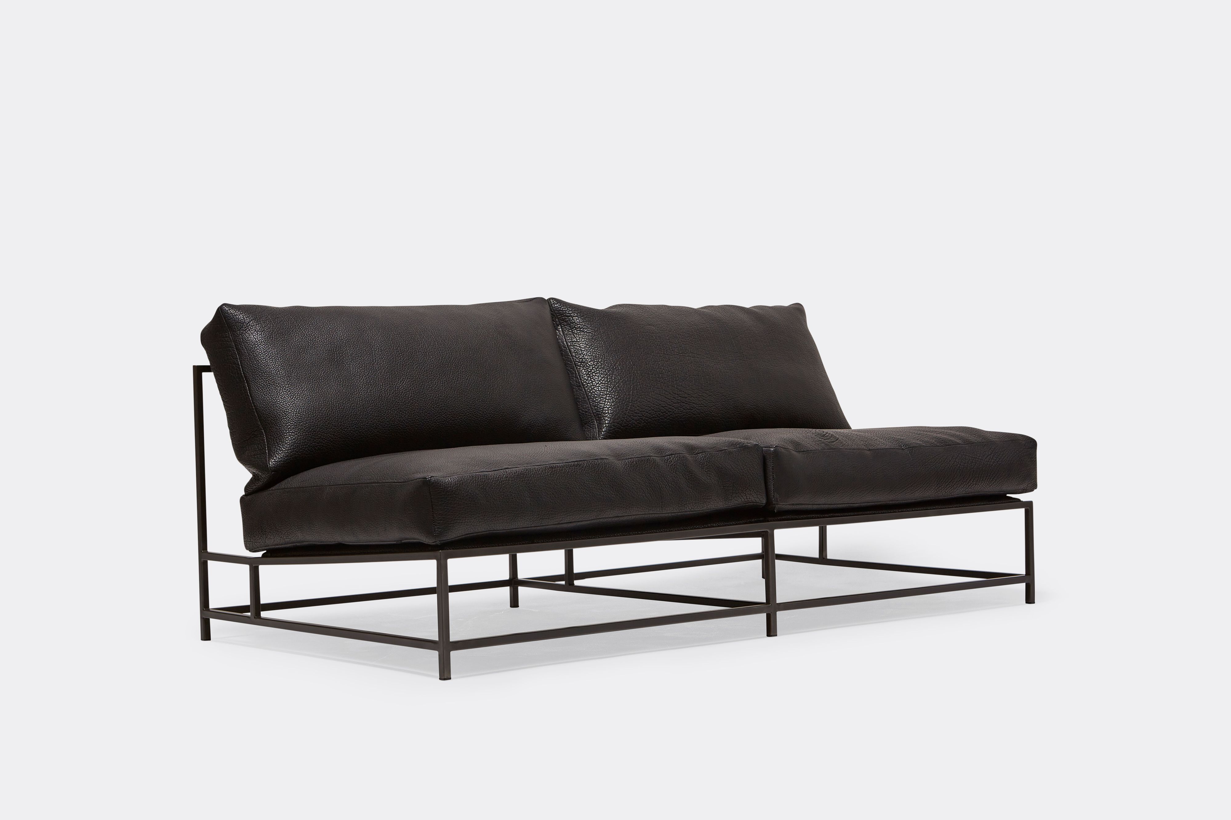 side of loveseat with black leather upholstery on black metal frame