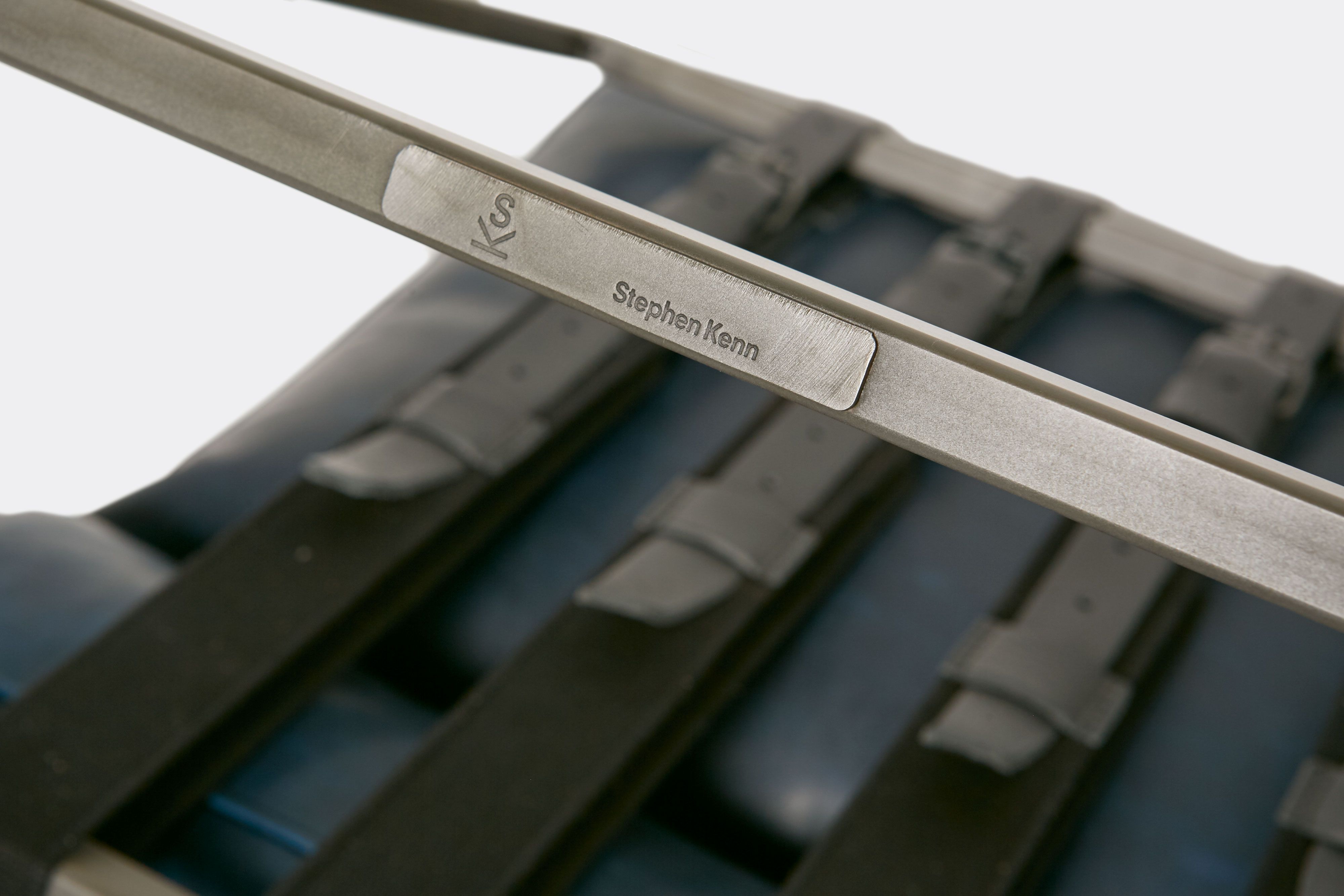 detail of lounge chair with blue leather upholstery and black leather belts on antique nickel metal frame