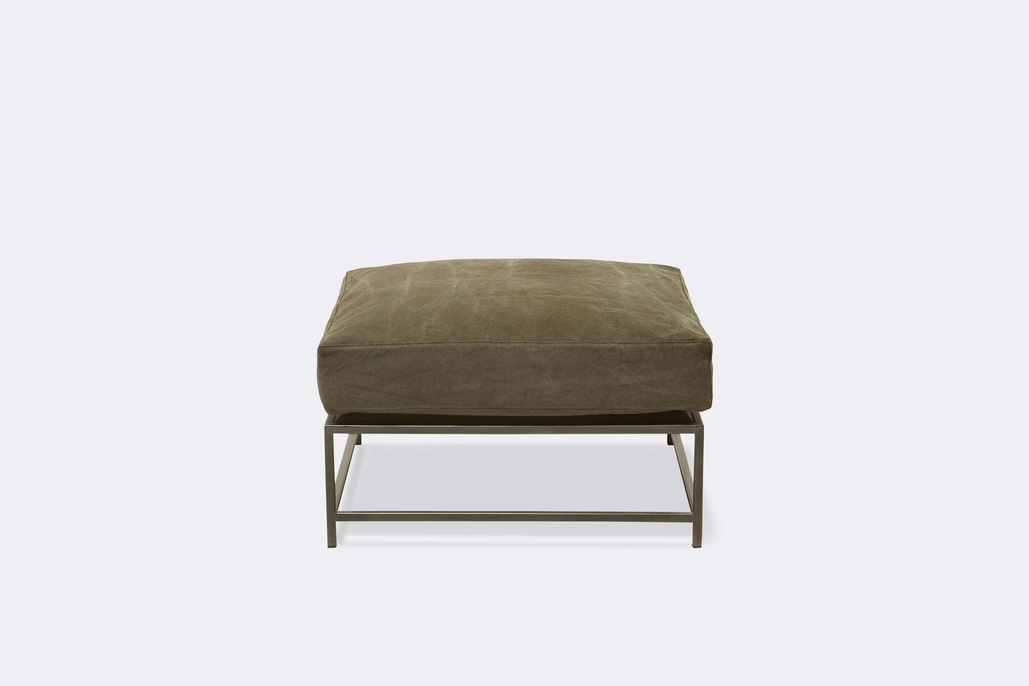 top view of green canvas ottoman with blackened steel frame