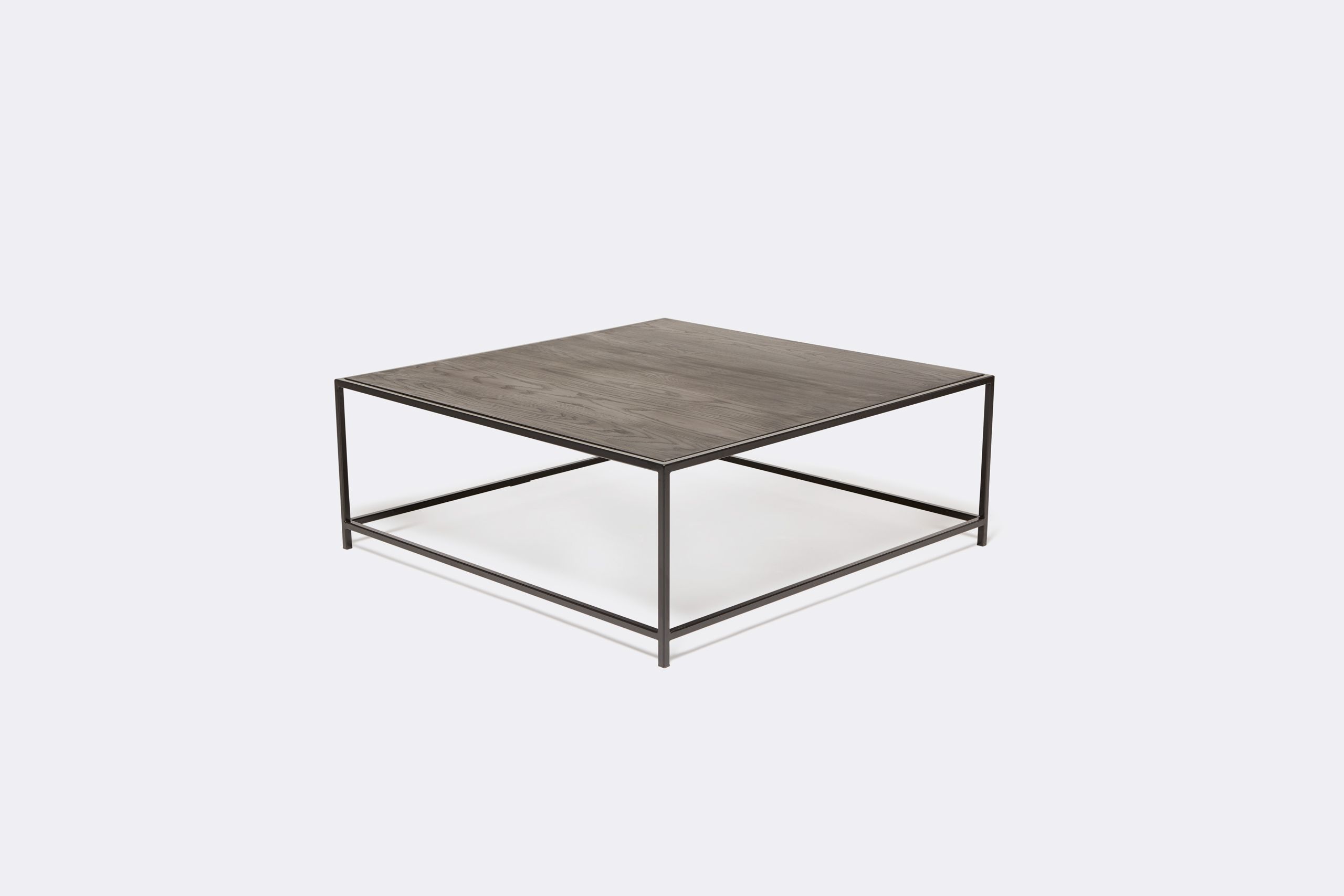 a black wood topped coffee table with a metal frame on a white background .