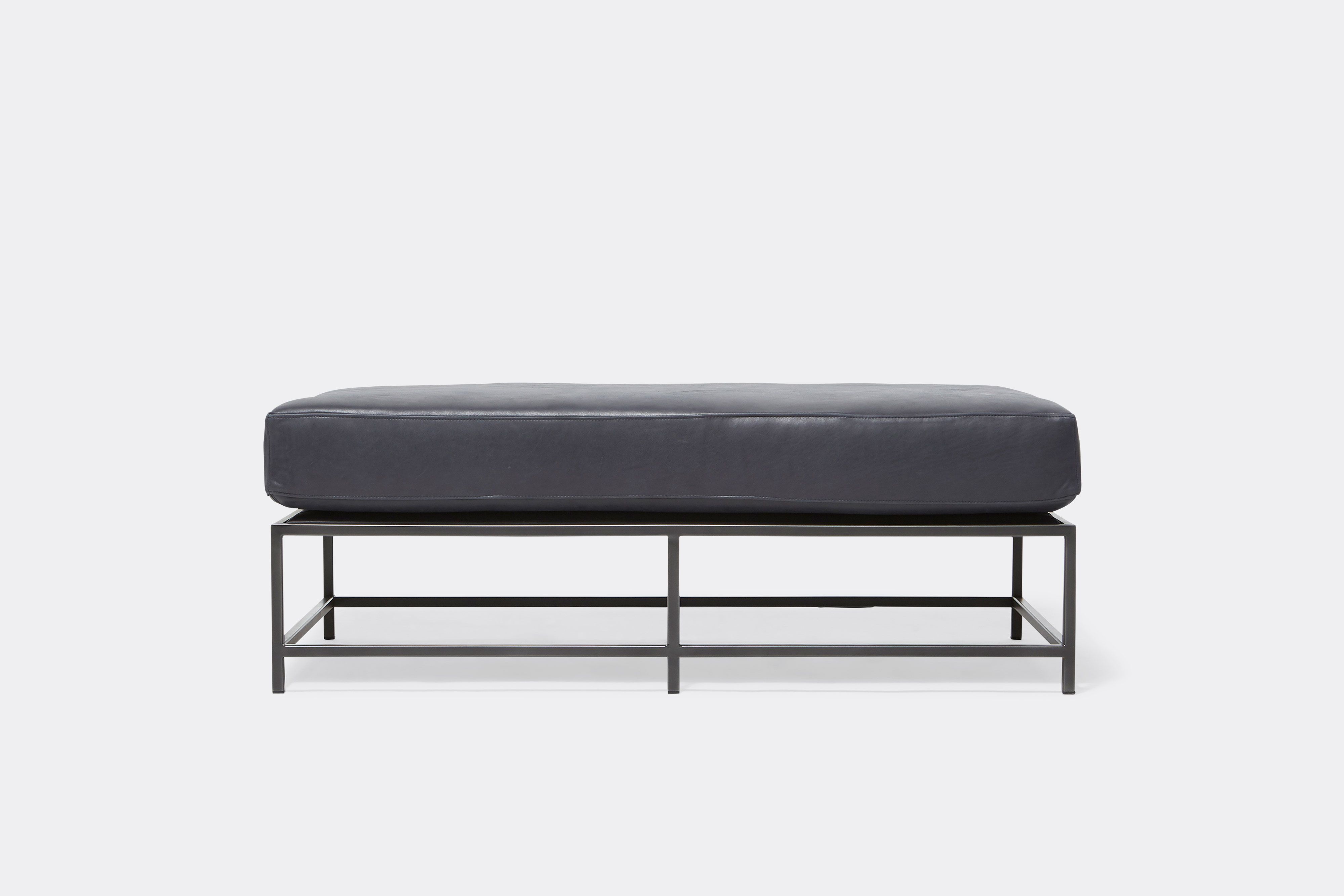 front of bench with blue leather upholstery on black metal frame