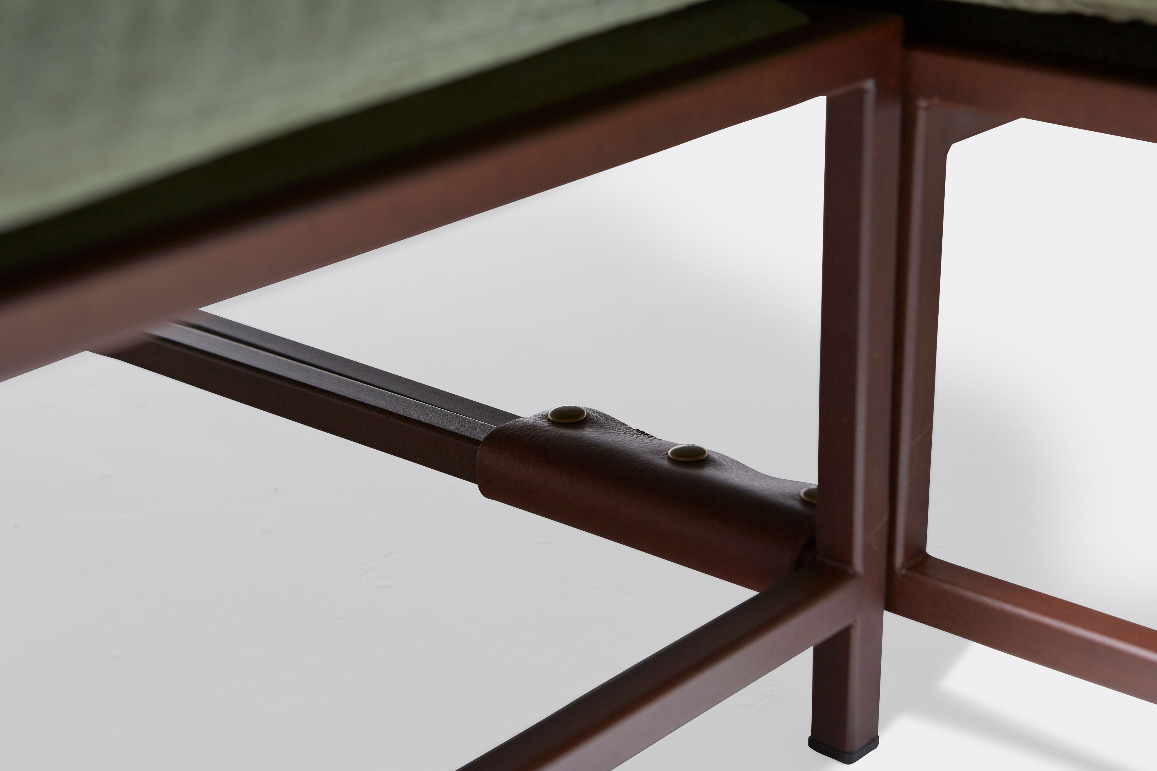 detail of sectional with green canvas upholstery on marble rust metal frame