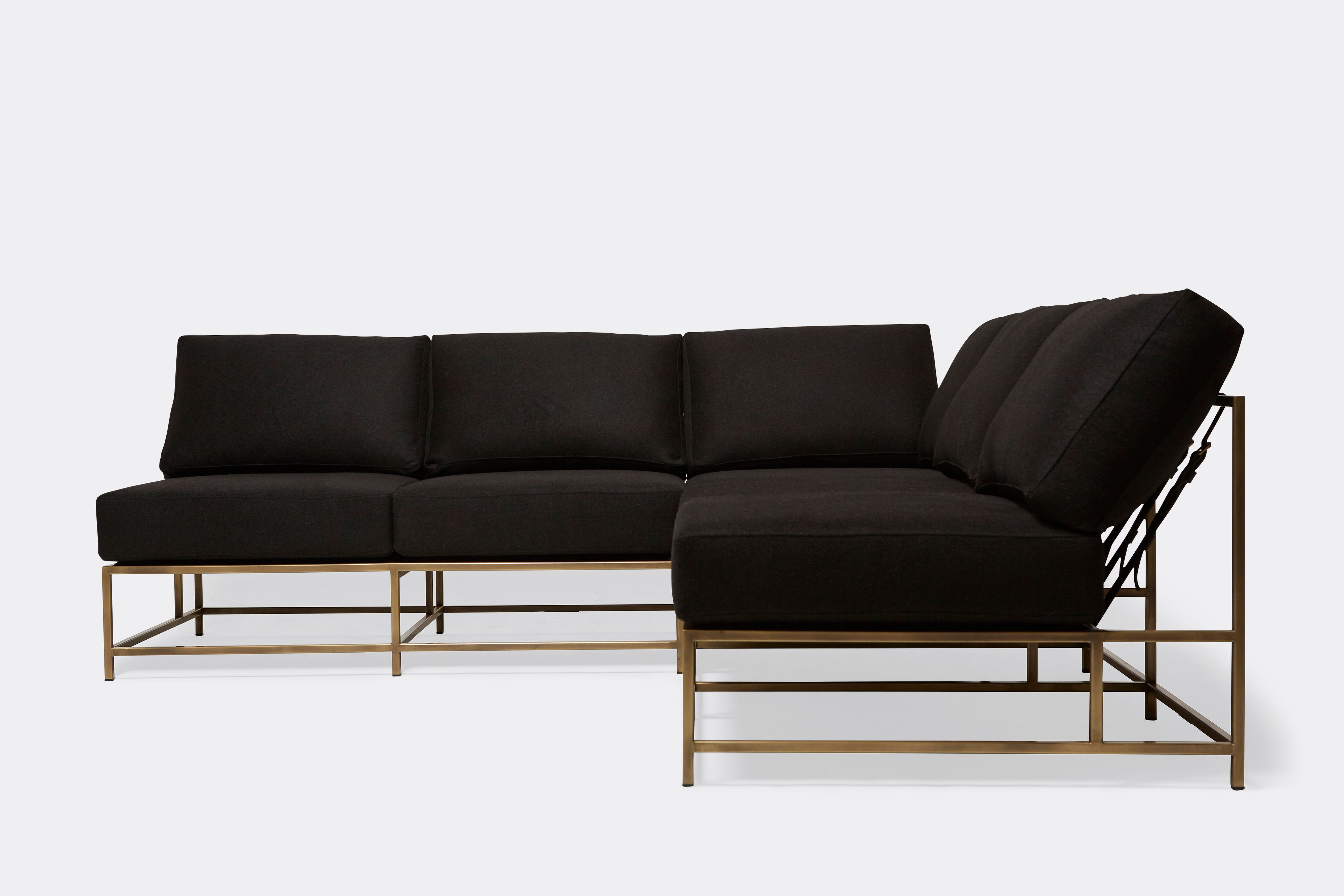 front of sectional with black wool upholstery on antique brass metal frame