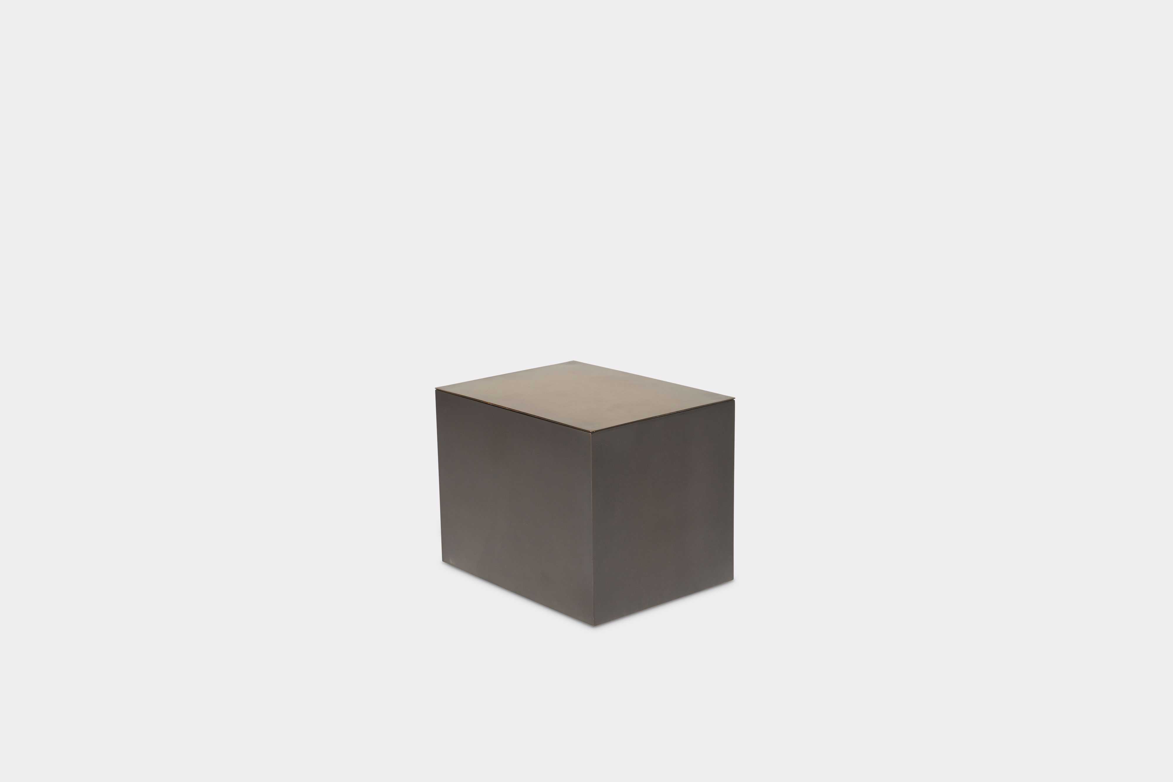 a blackened steel small table with a brass finished top