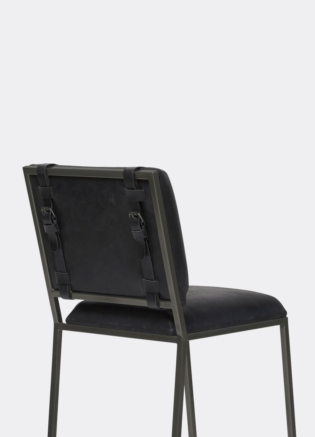 A black leather bar stool with a steel frame and black leather belts shown on a white background .