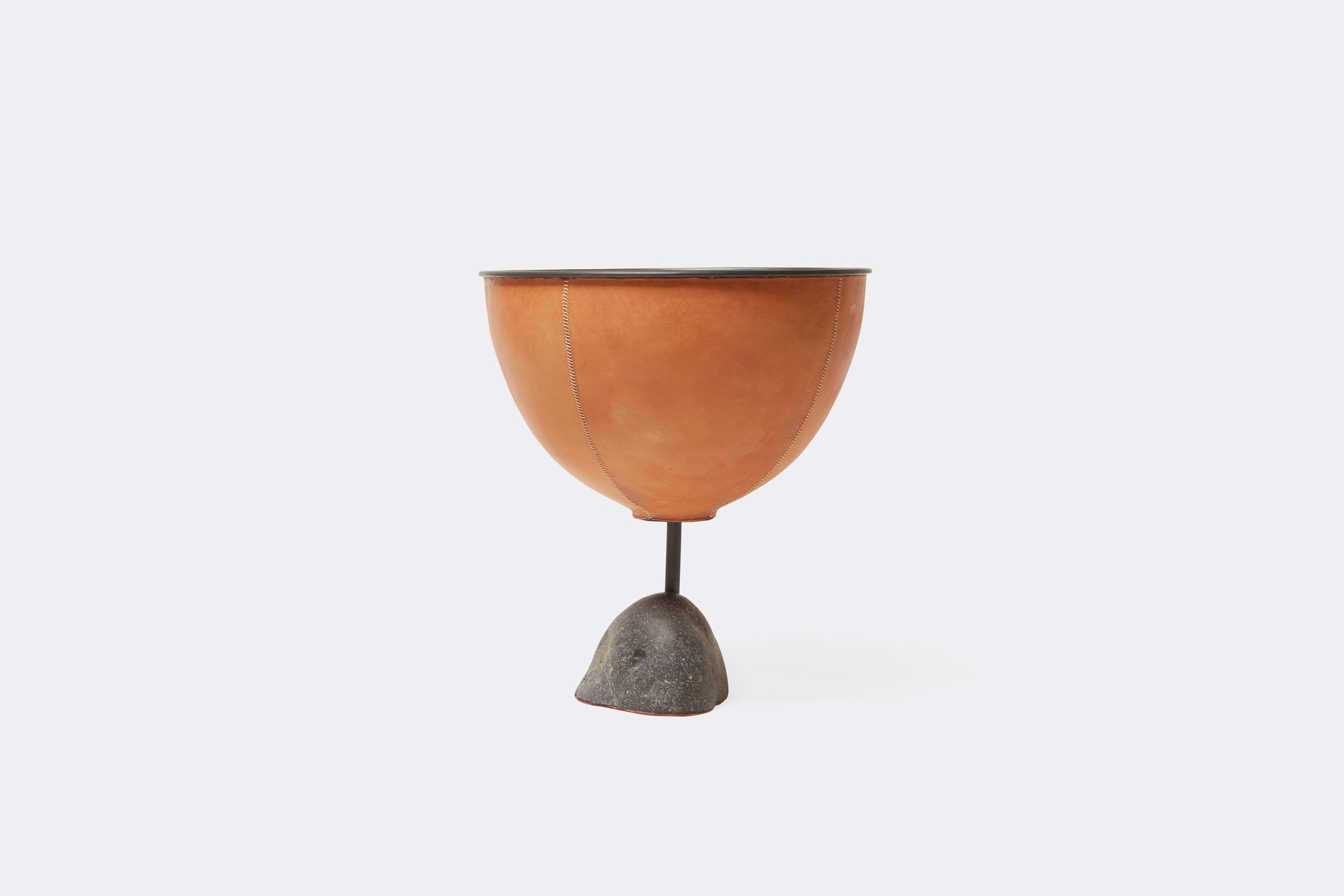 a leather wrapped steel planter with a steel and stone base shown on a white background .