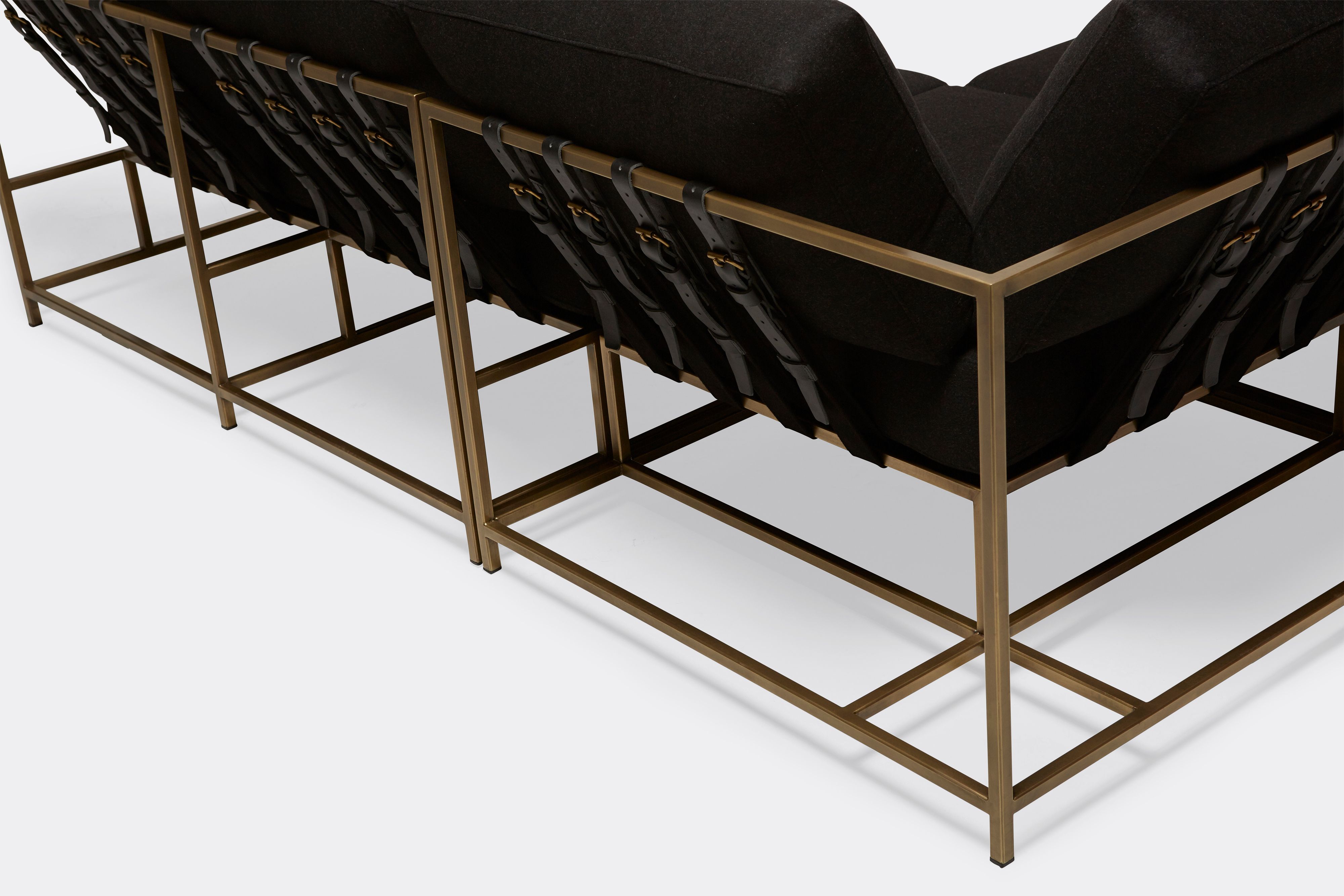 detail of sectional with black wool upholstery on antique brass metal frame