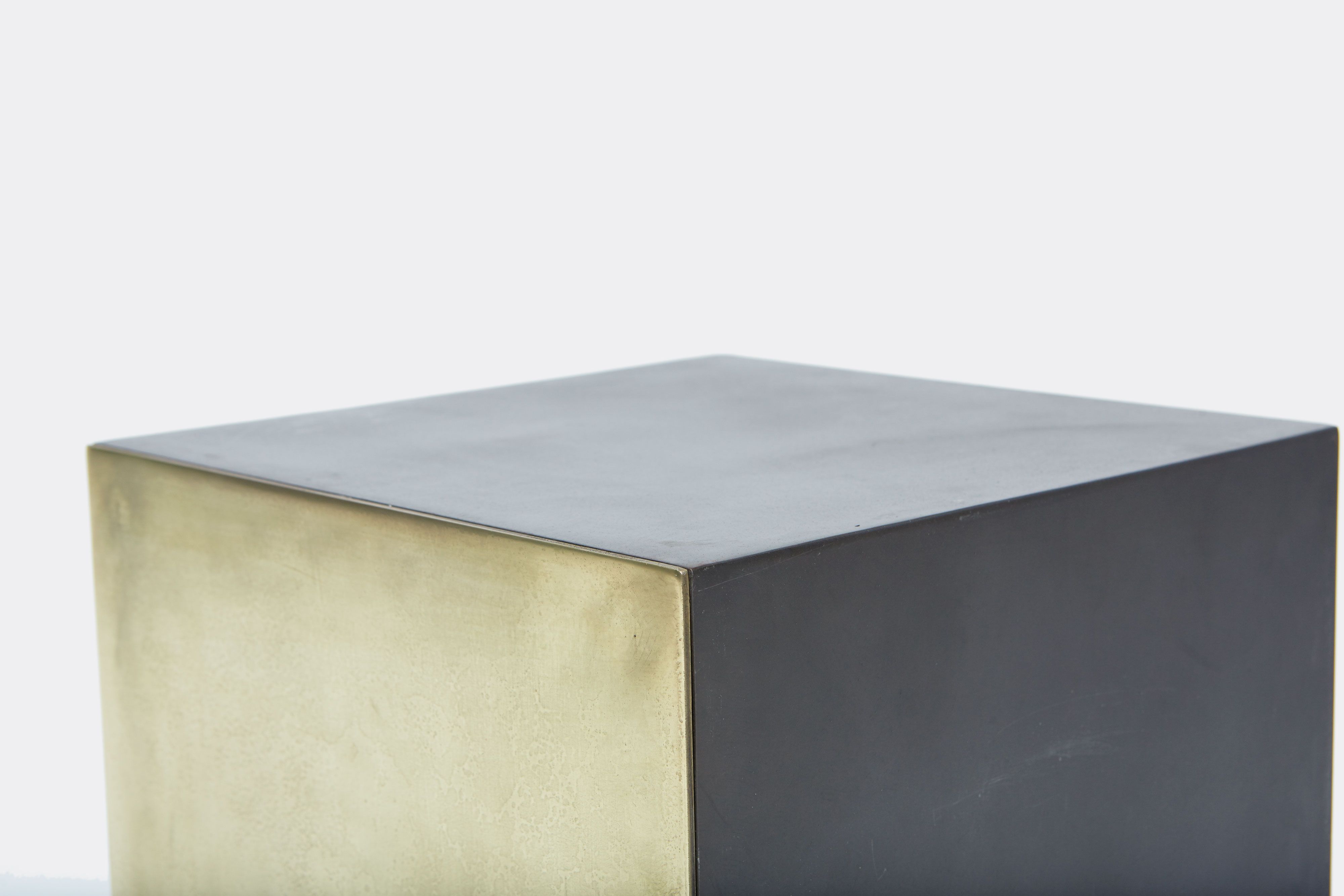 detail of block table made with tarnished brass and black metal frame