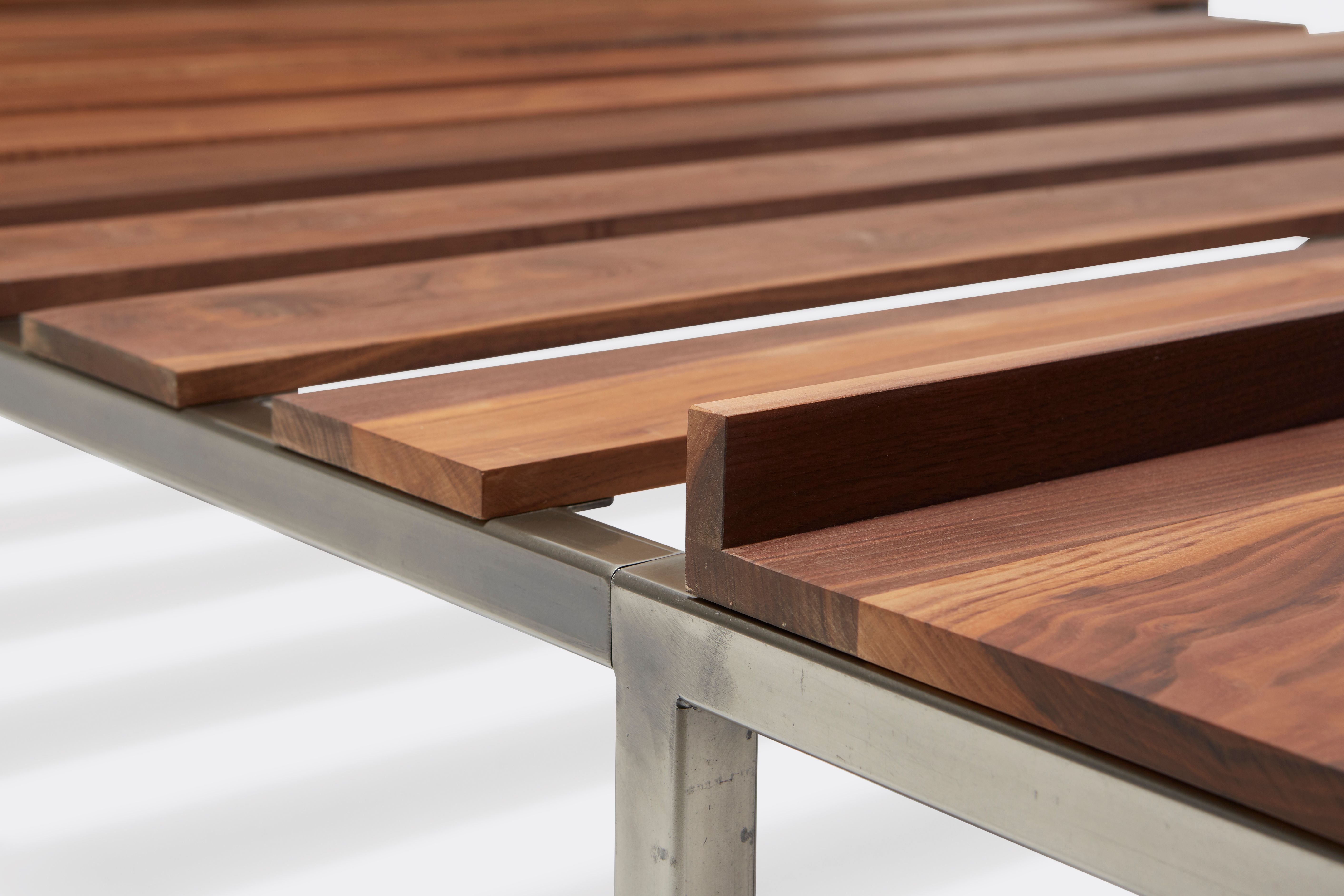 a steel and walnut wood bed with a brown leather headboard on a white background