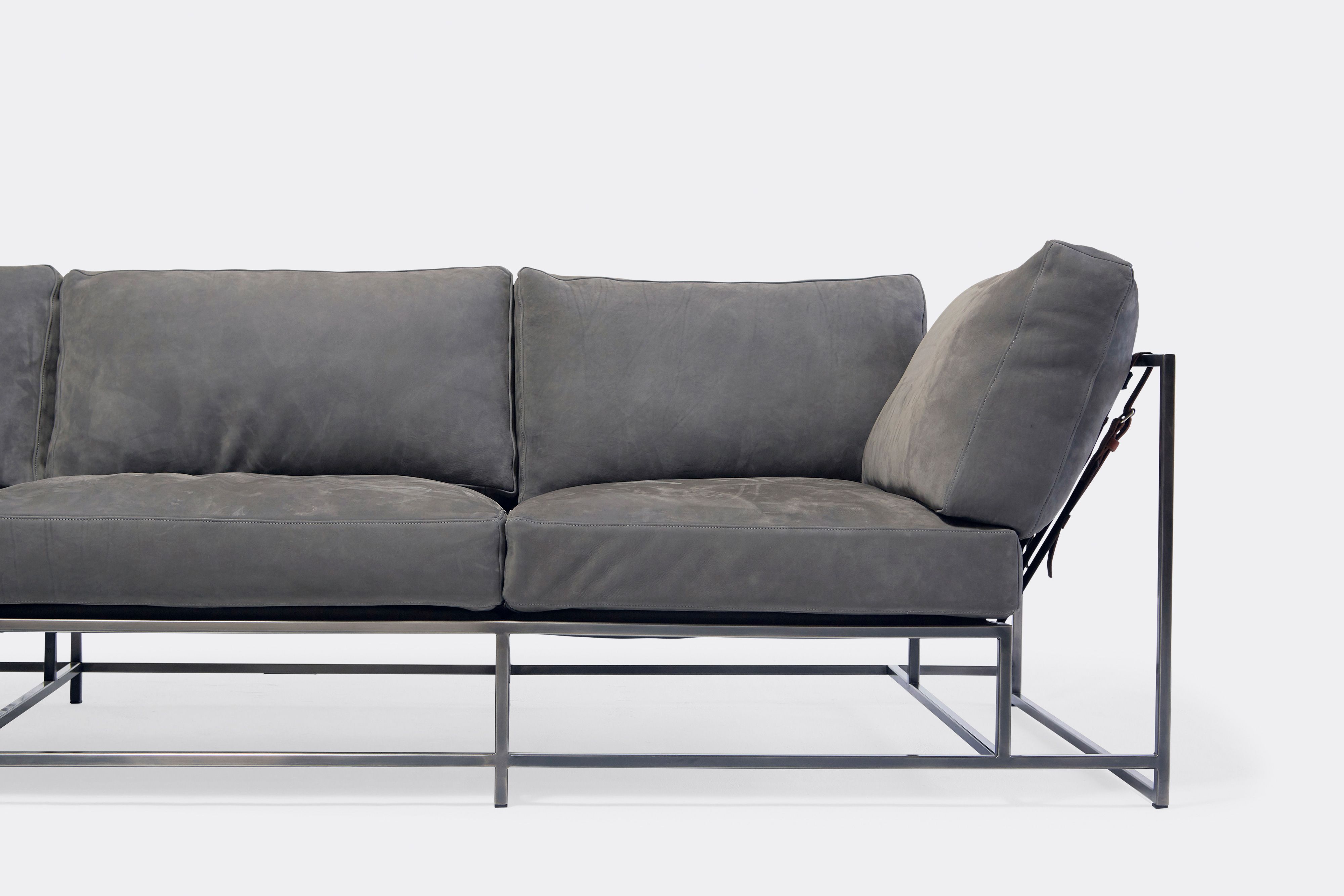 Front of sofa with grey leather upholstery and antique nickel metal frame