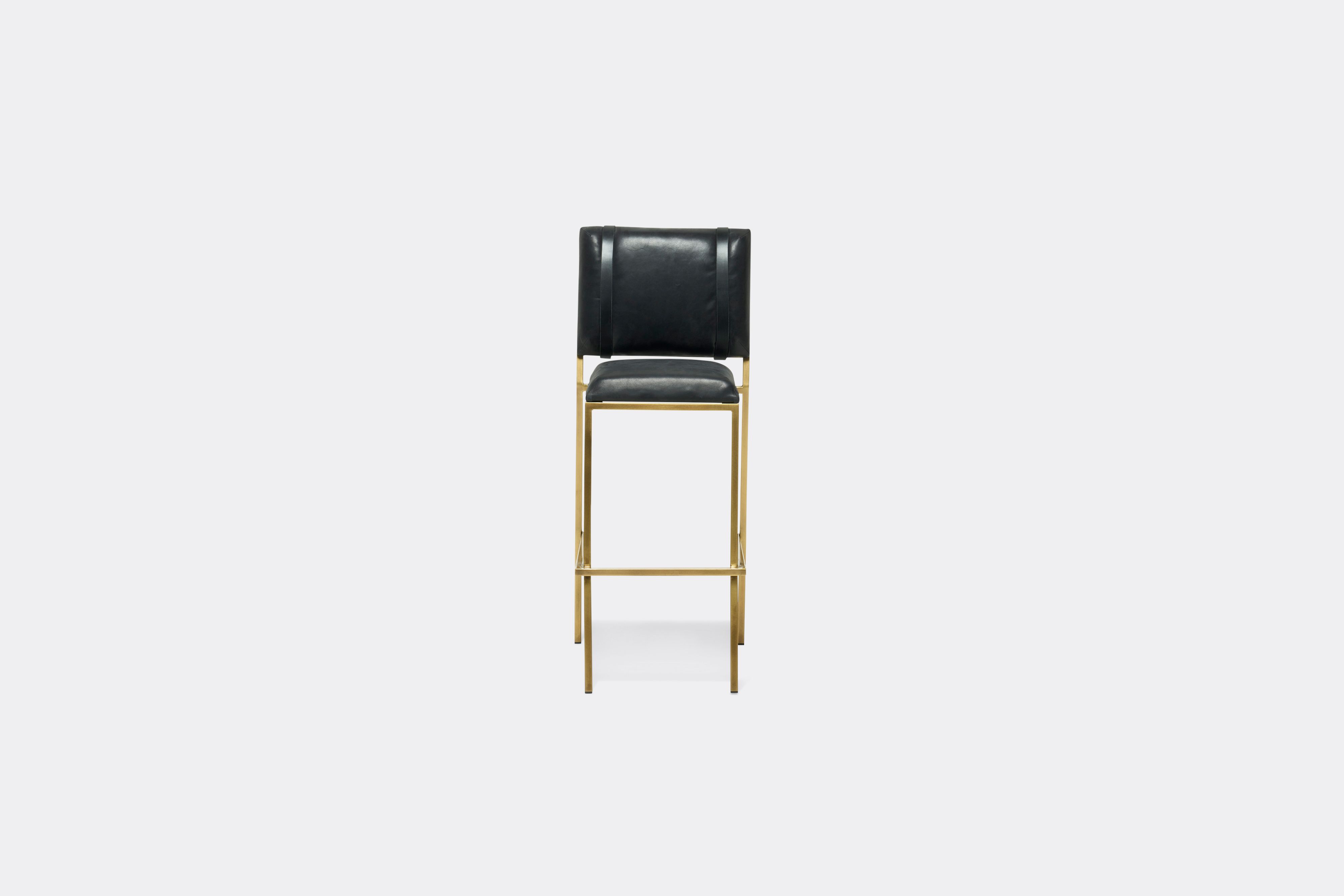 Front view of black leather barstool with antique brass metal frame