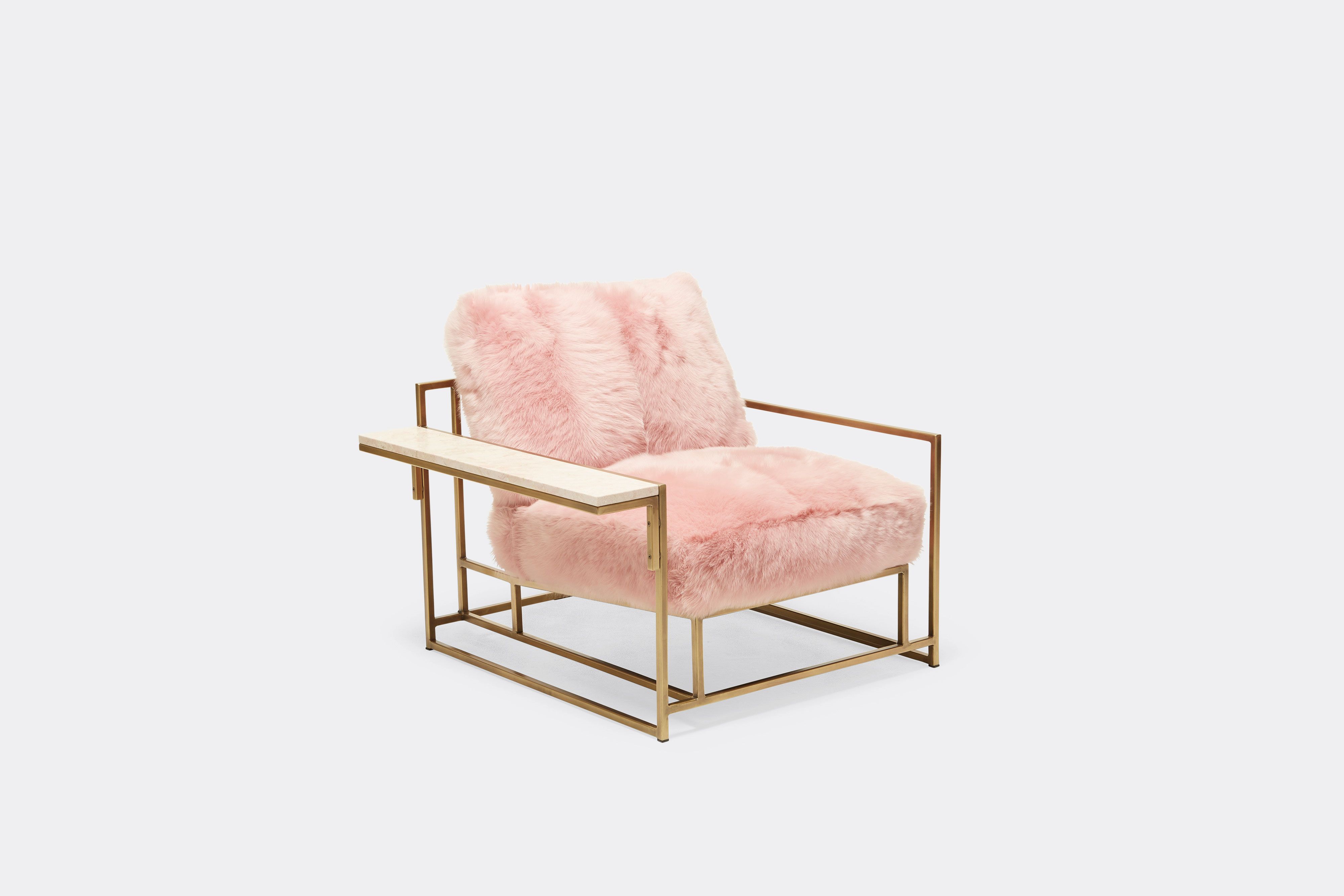 side view of armchair with pink shearing upholstery on antique brass metal frame