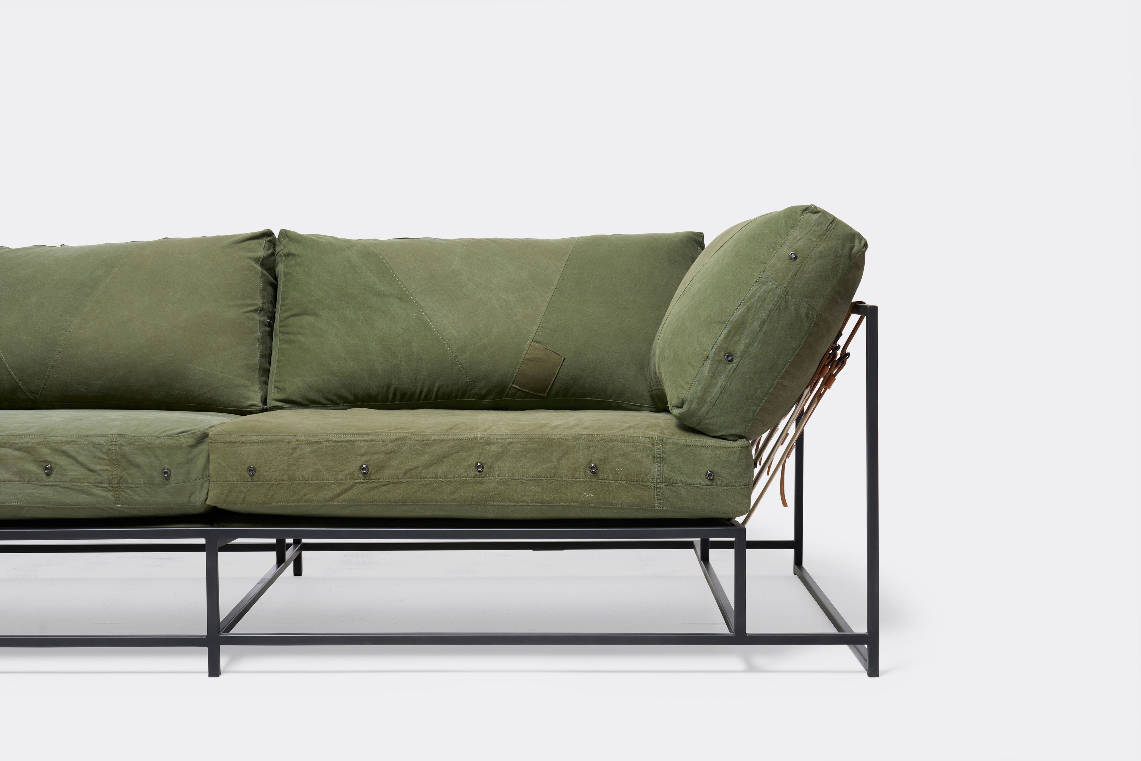 Front of two seat sofa with green canvas upholstery and black metal frame