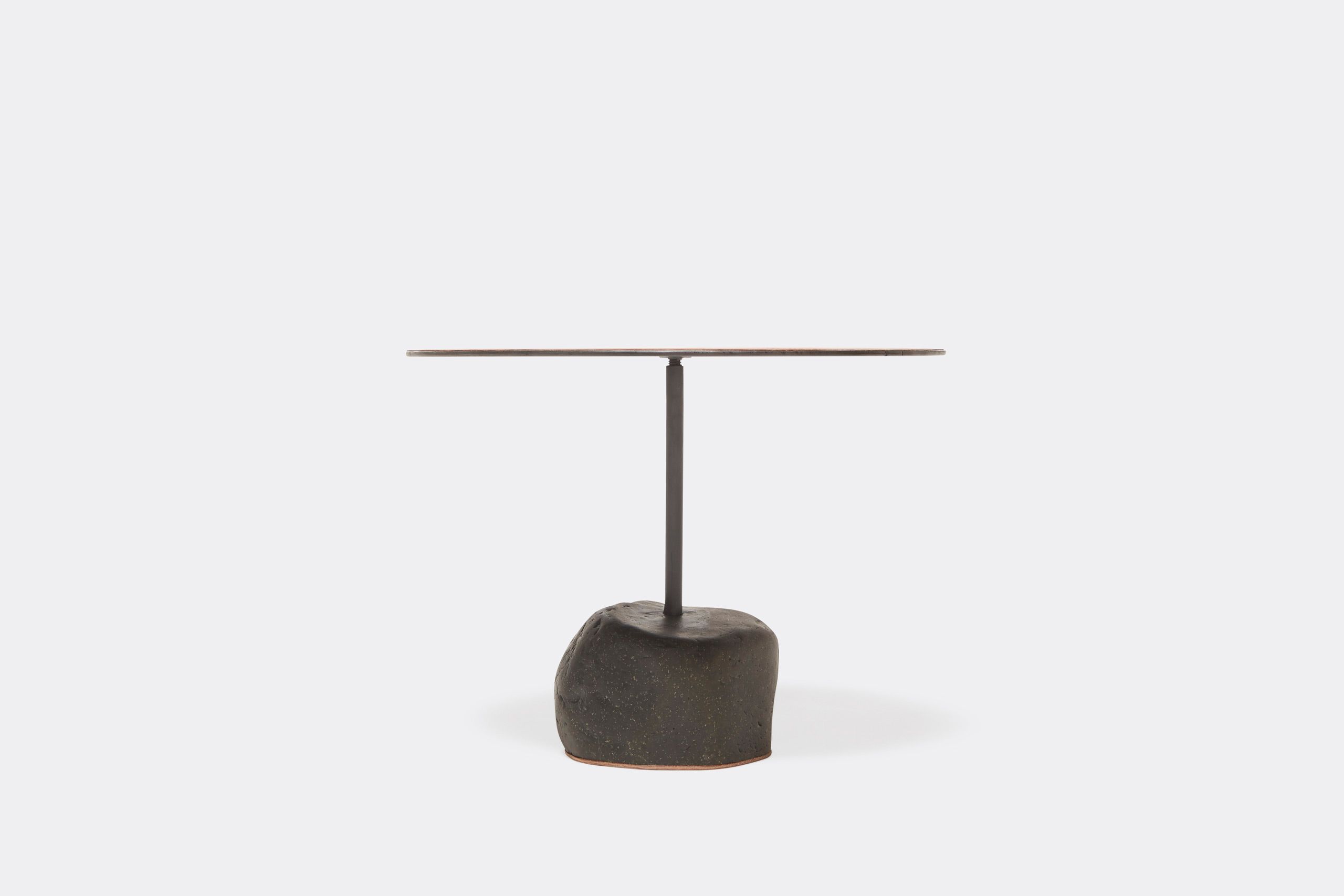 a round table with a brown leather top and a metal frame with a stone base shown on a white background .