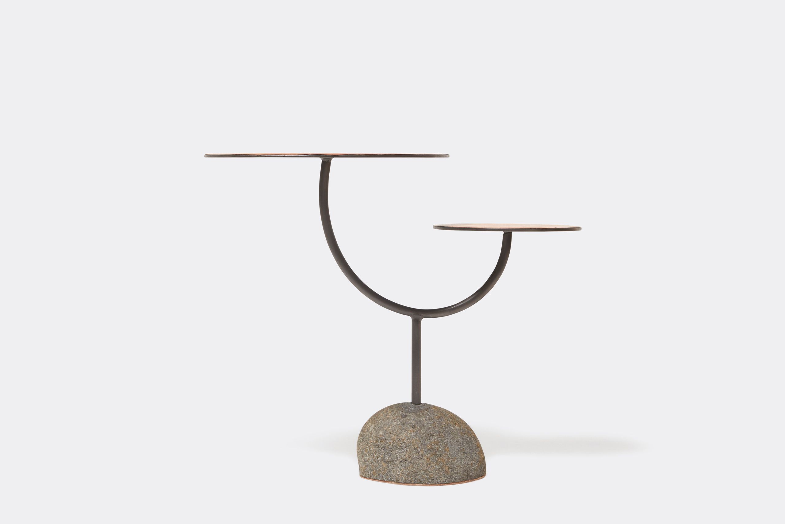 a round table with a brown leather top and a metal steel frame and stone base shown on a white background .