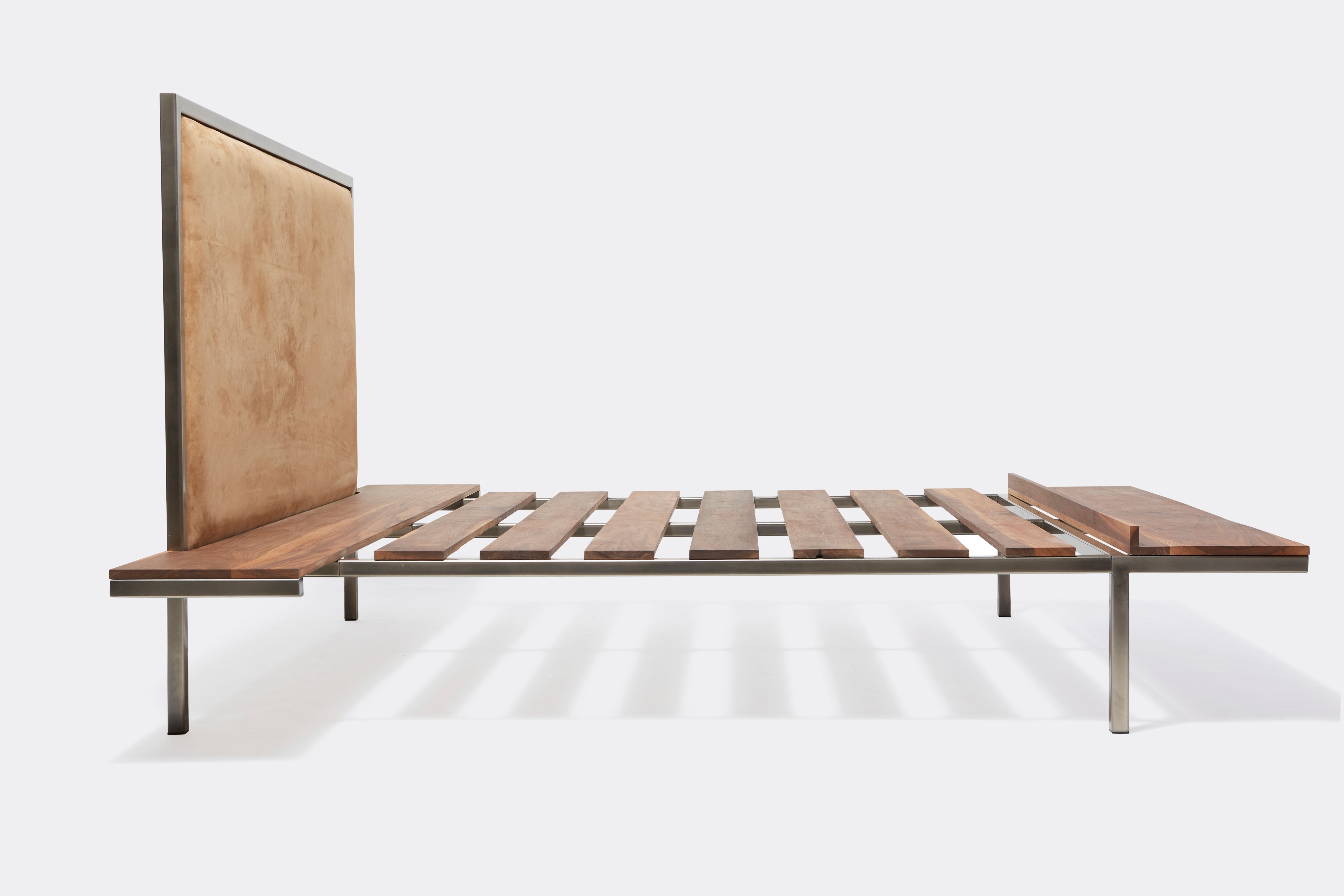 a steel and walnut wood bed with a brown leather headboard on a white background