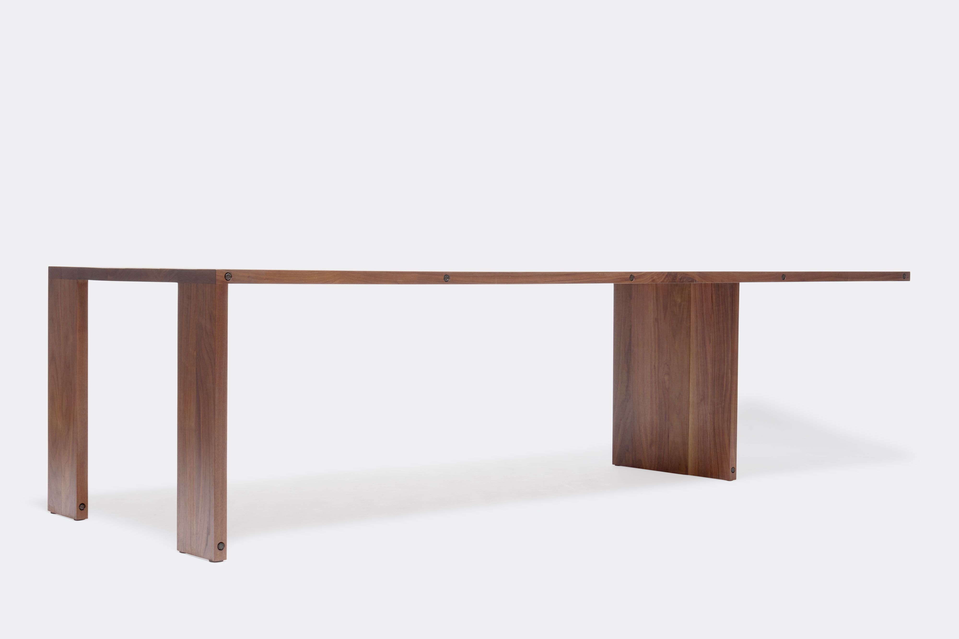 a long walnut wooden table on a white background .